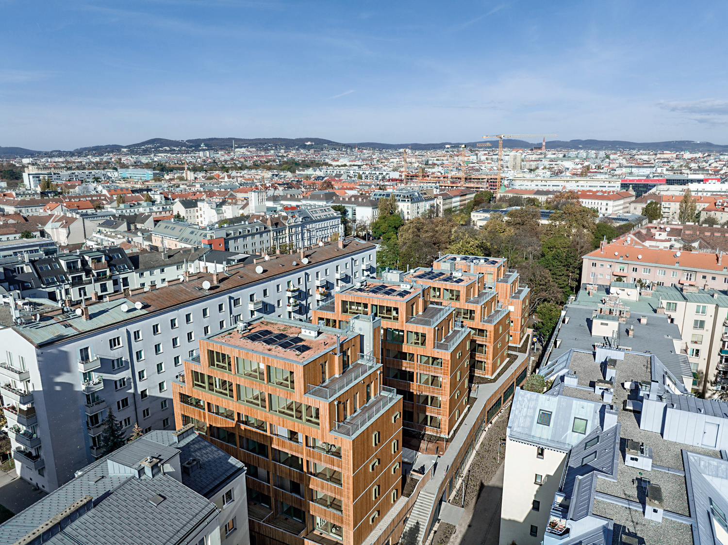 Wo bisher ein Supermarkt mit Parkplatz war, schaffen vier Holzbauten 85 Wohnungen. Der Supermarkt liegt nun im neuen Sockelbau.