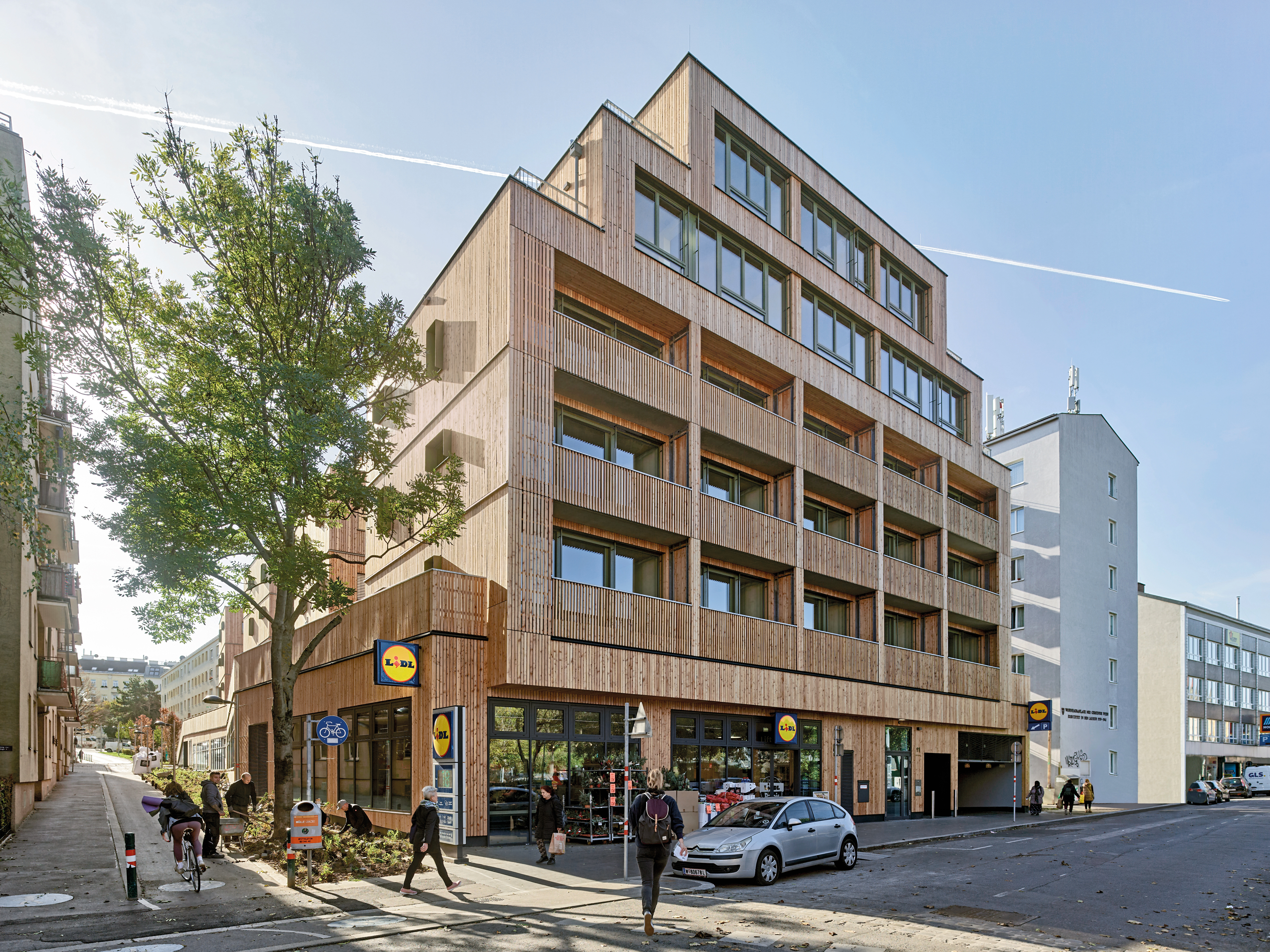 Der Sockel mit Supermarkt gleicht den Höhenunterschied in Längsrichtung aus und schafft eine horizontale Plattform für die Wohnbauten.