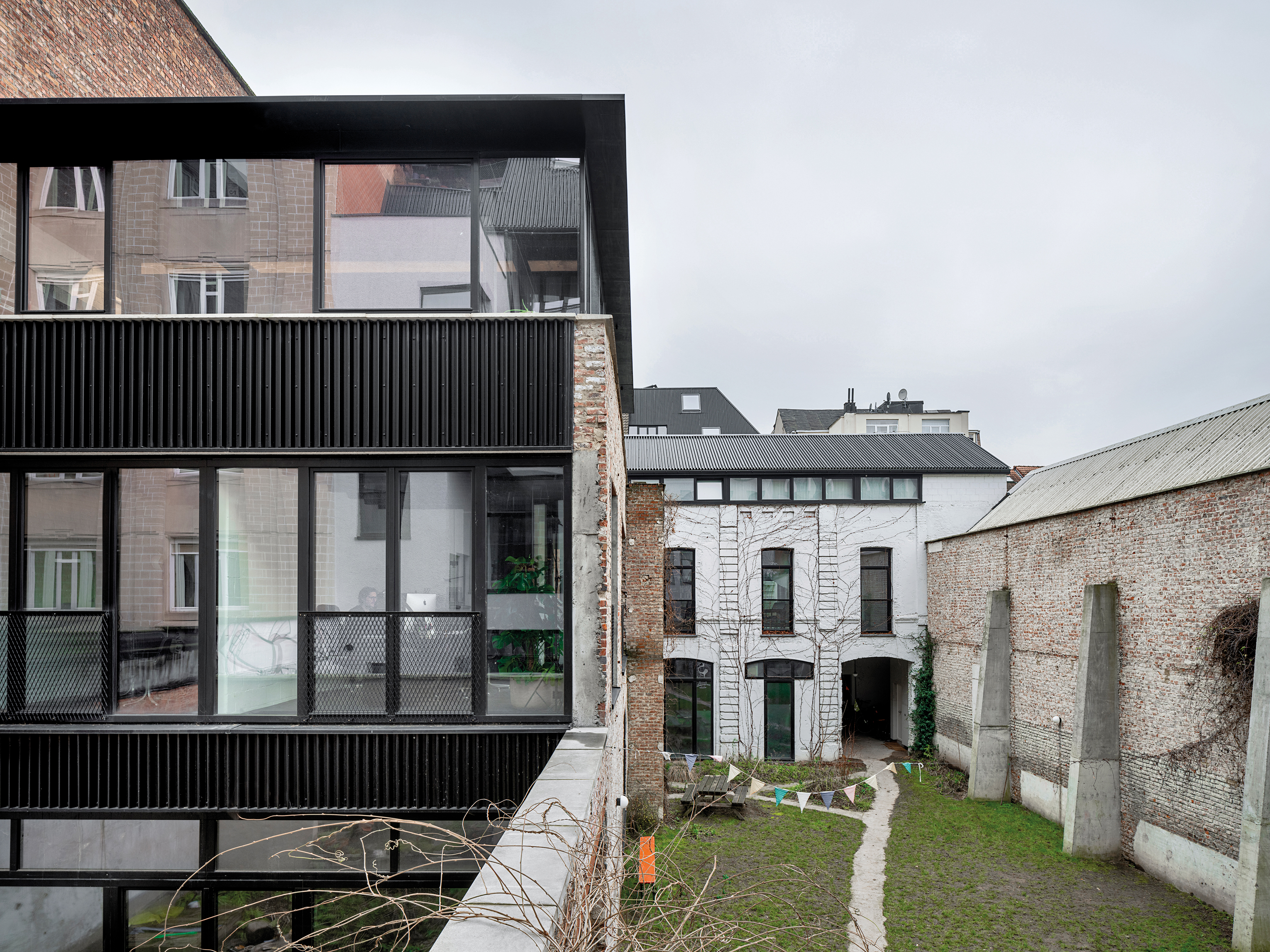 Im Zentrum des neu geschaffenen Gartens liegt das ehemalige Stallgebäude. Es wurde aufgestockt und beherbergt heute Gemeinschafts- und Atelierräume.