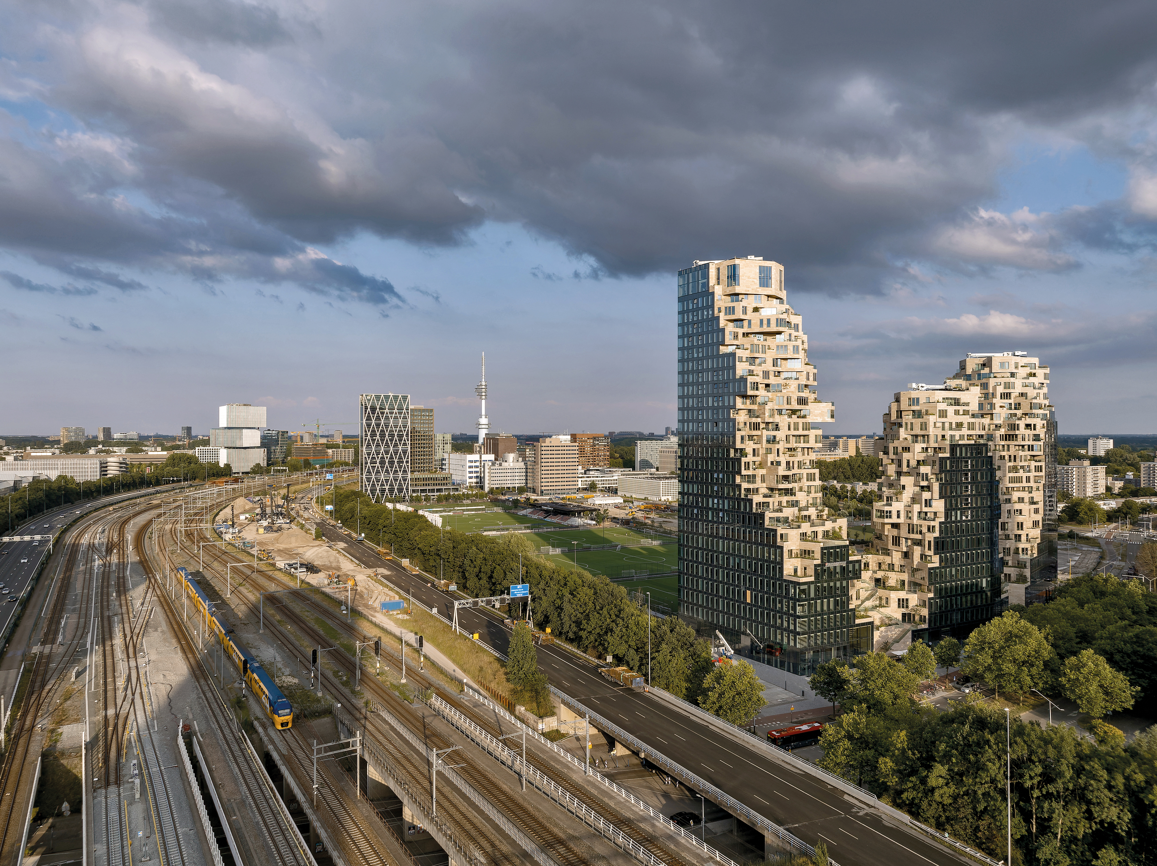 The perimeter facades, smooth and glazed to match the neighbouring office buildings, contrast with the greened terraced facades, which evoke the appearance of an overgrown ruin.