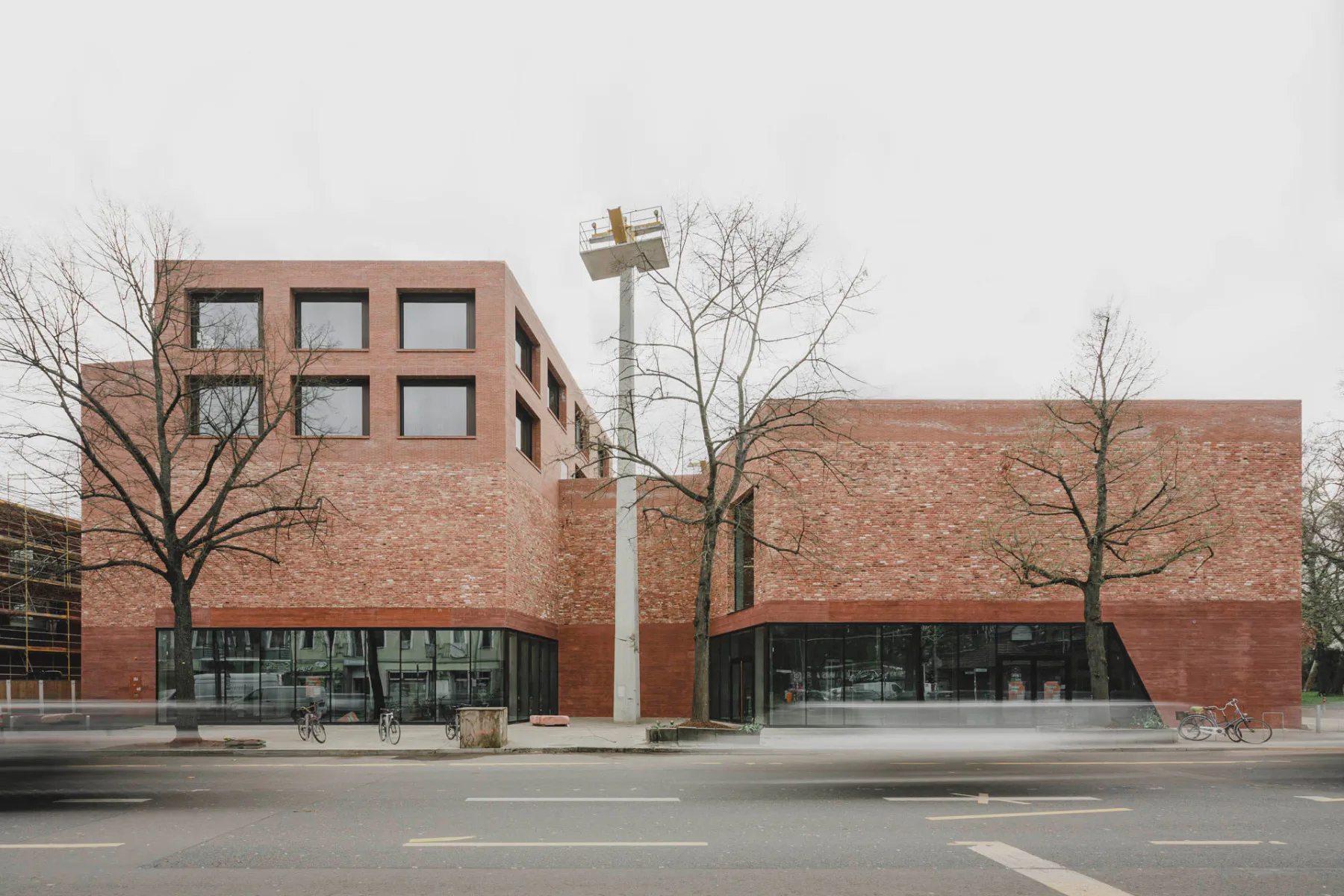 Alte und neue Ziegel sowie rot gefärbter Sichtbeton prägen die Fassaden der Spore Initiative in Berlin.