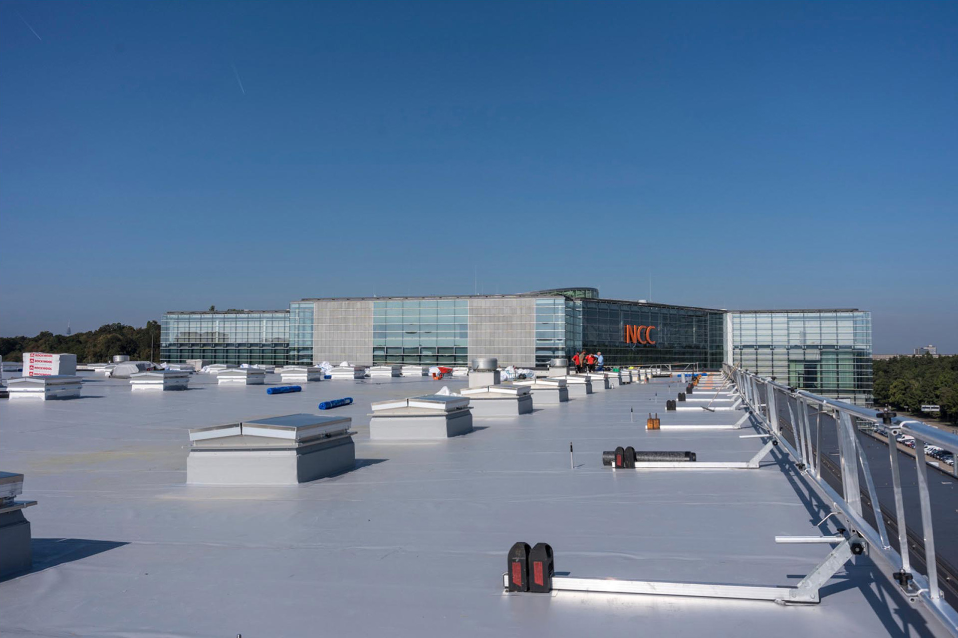 Auf dem 7500 qm großen Dach der Halle 4A befinden sich insgesamt 98 Rauch- und Wärmeabzugsanlagen (RWA) und acht Lüfter. Die Hallendächer der NürnbergMesse werden mit neuen Dachbahnen und PV-Anlagen versehen. Begonnen wurde mit Halle 4A.