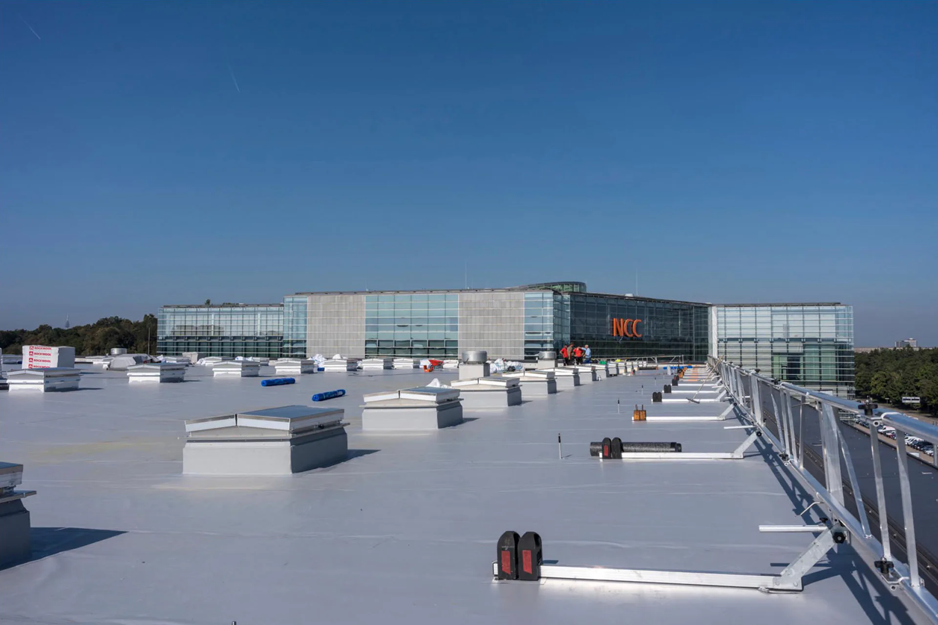 Auf dem 7500 qm großen Dach der Halle 4A befinden sich insgesamt 98 Rauch- und Wärmeabzugsanlagen (RWA) und acht Lüfter. Die Hallendächer der NürnbergMesse werden mit neuen Dachbahnen und PV-Anlagen versehen. Begonnen wurde mit Halle 4A.