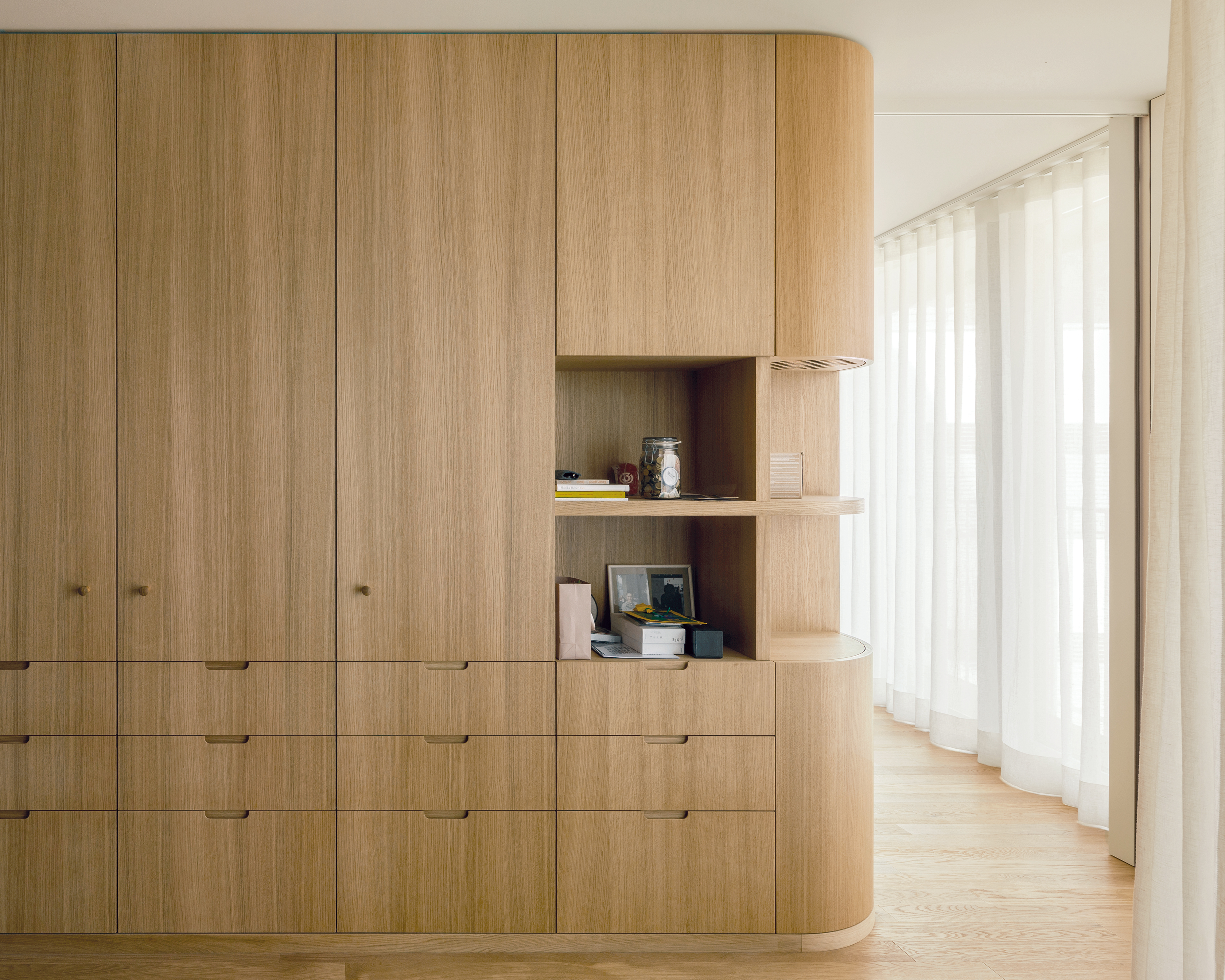 Schrankmöbel aus Eiche zonieren die Wohnung der Bauherren. Sie bieten viel Stauraum und nehmen sogar die Lüftungstechnik auf.