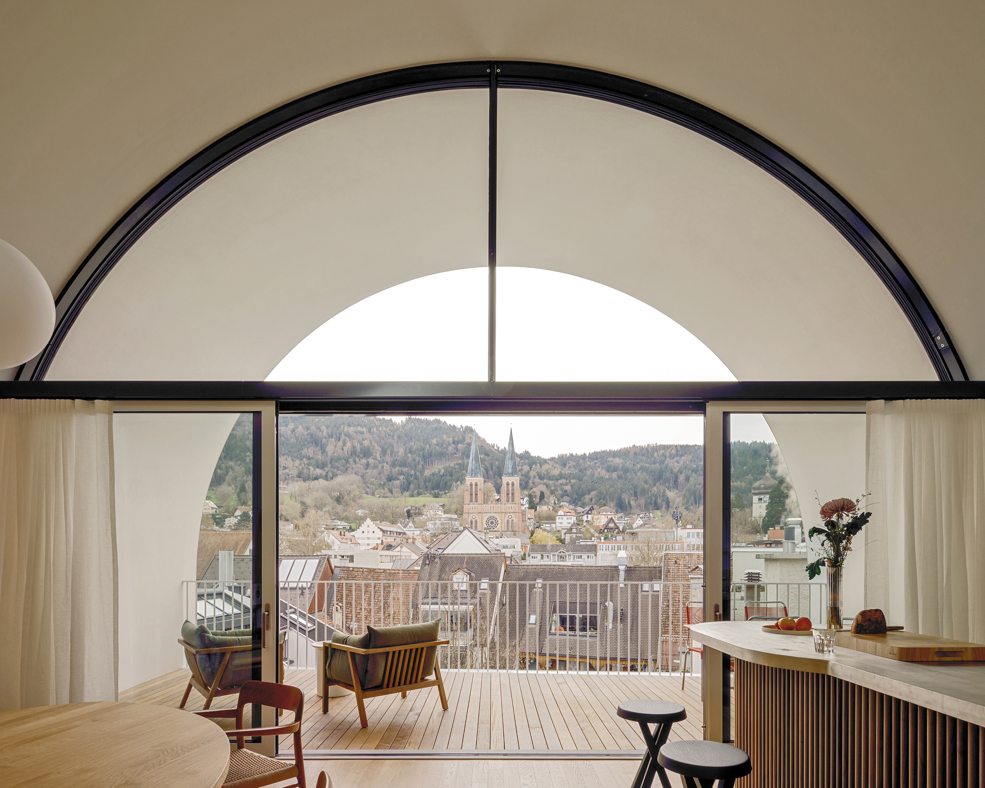 A loggia beneath the great barrel roof offers views across the roofscape of the city of Bregenz.