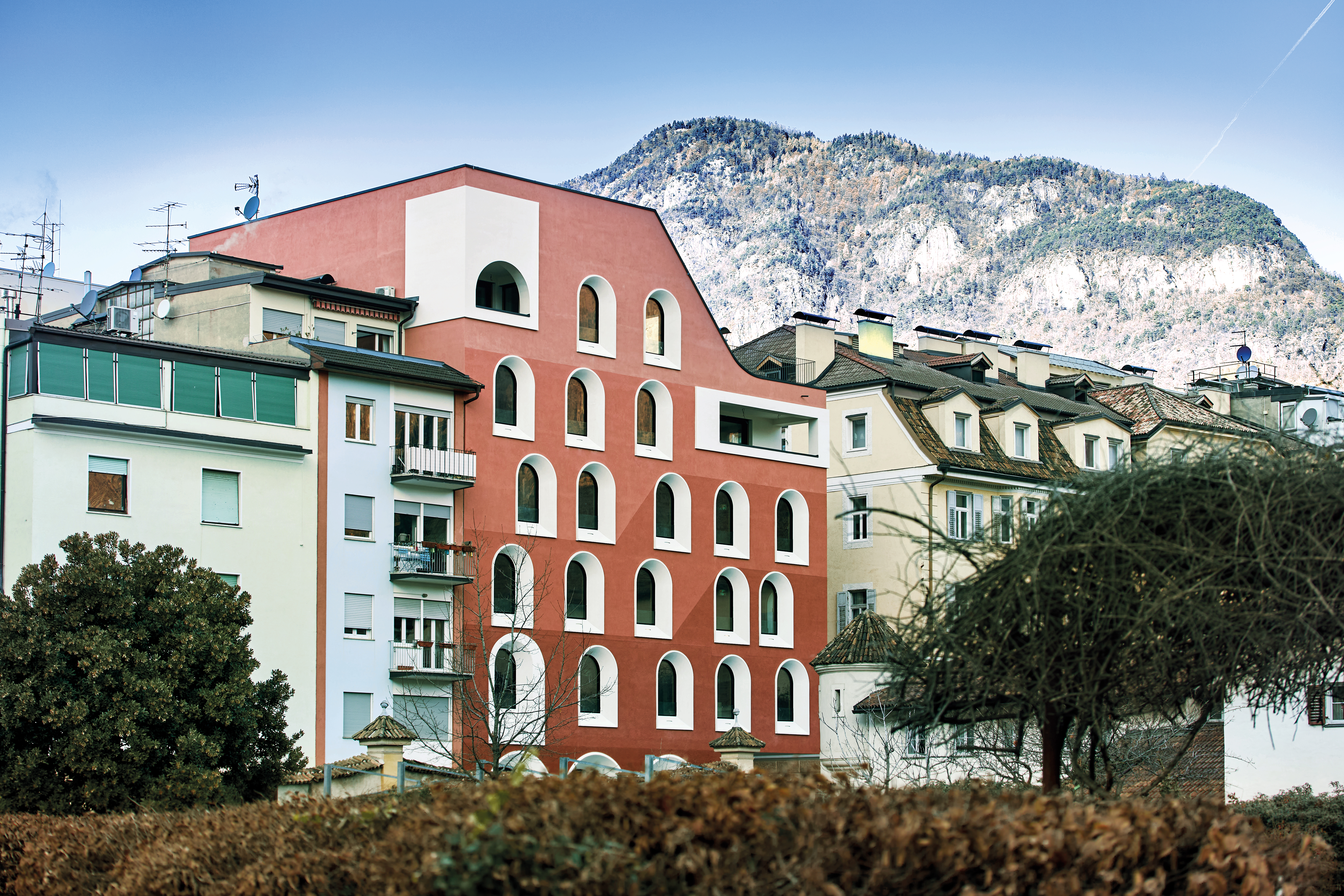 Das Hotel La Briosa fällt auf, ohne seine Umgebung zu dominieren. In den obersten beiden Etagen wohnt die Bauherrenfamilie, die das Hotel auch betreibt. Die Intensität der rotbraunen Putzfassade variiert von unten nach oben.