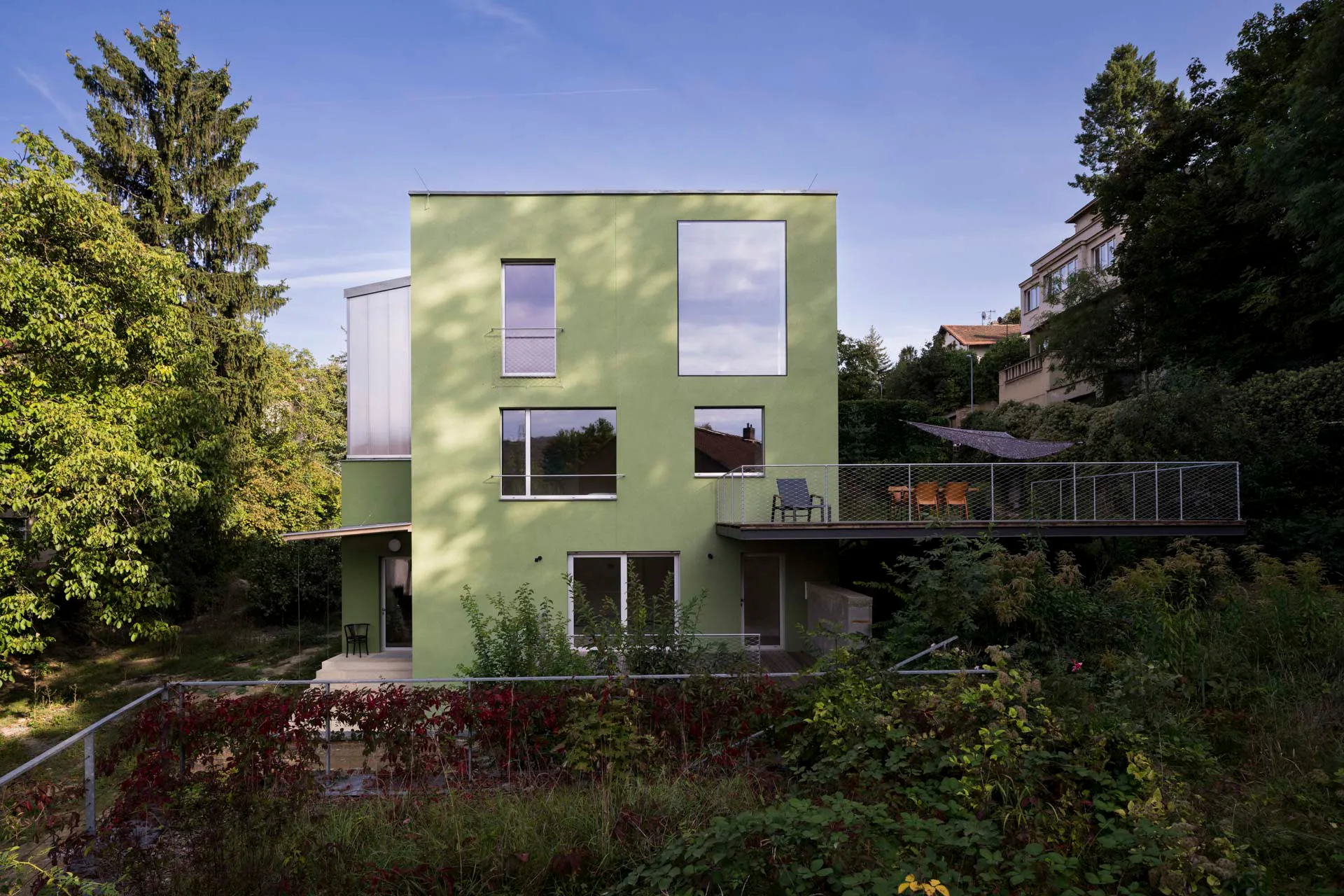 Feinkörniger Putz ziert die grüne Fassade der Familienvilla.