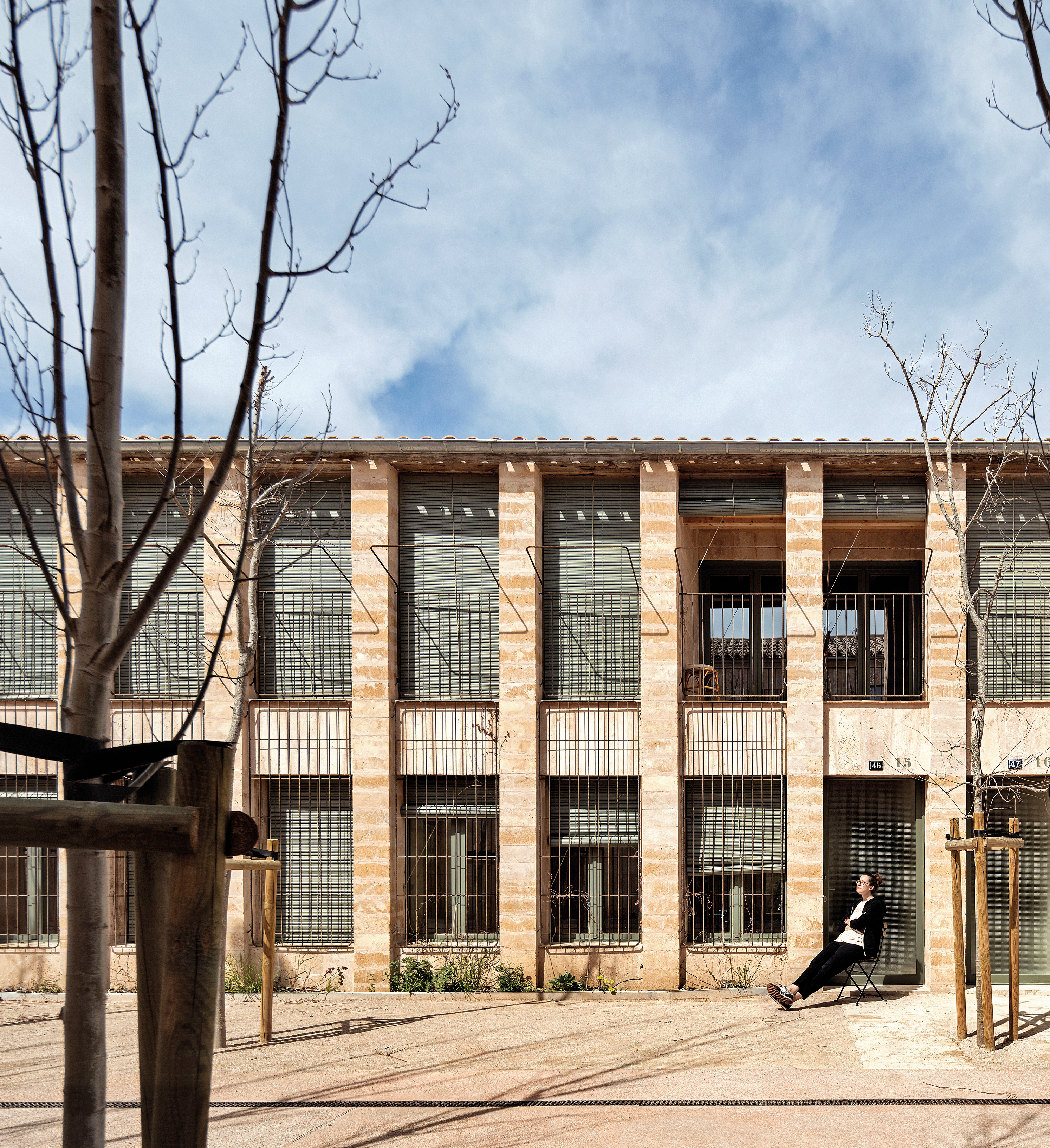 The two-storey Salvador Espriu apartment building in Palma blends into its surroundings with a shallow pitched roof and rhythmically structured facades.