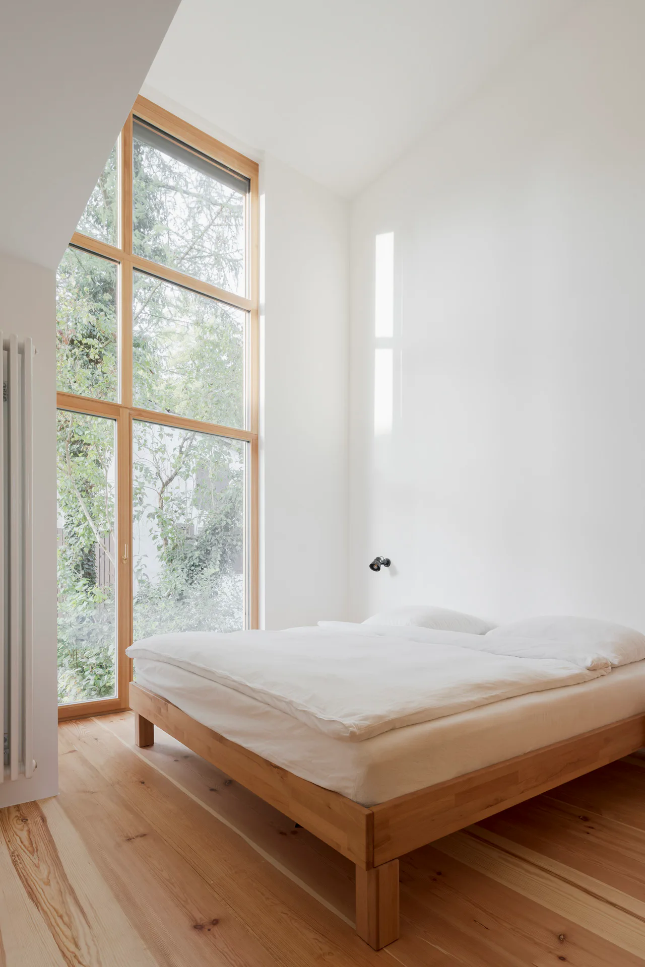 Ein großzügiges Schlafzimmer mit doppelter Raumhöhe gibt den Blick in die Landschaft frei.