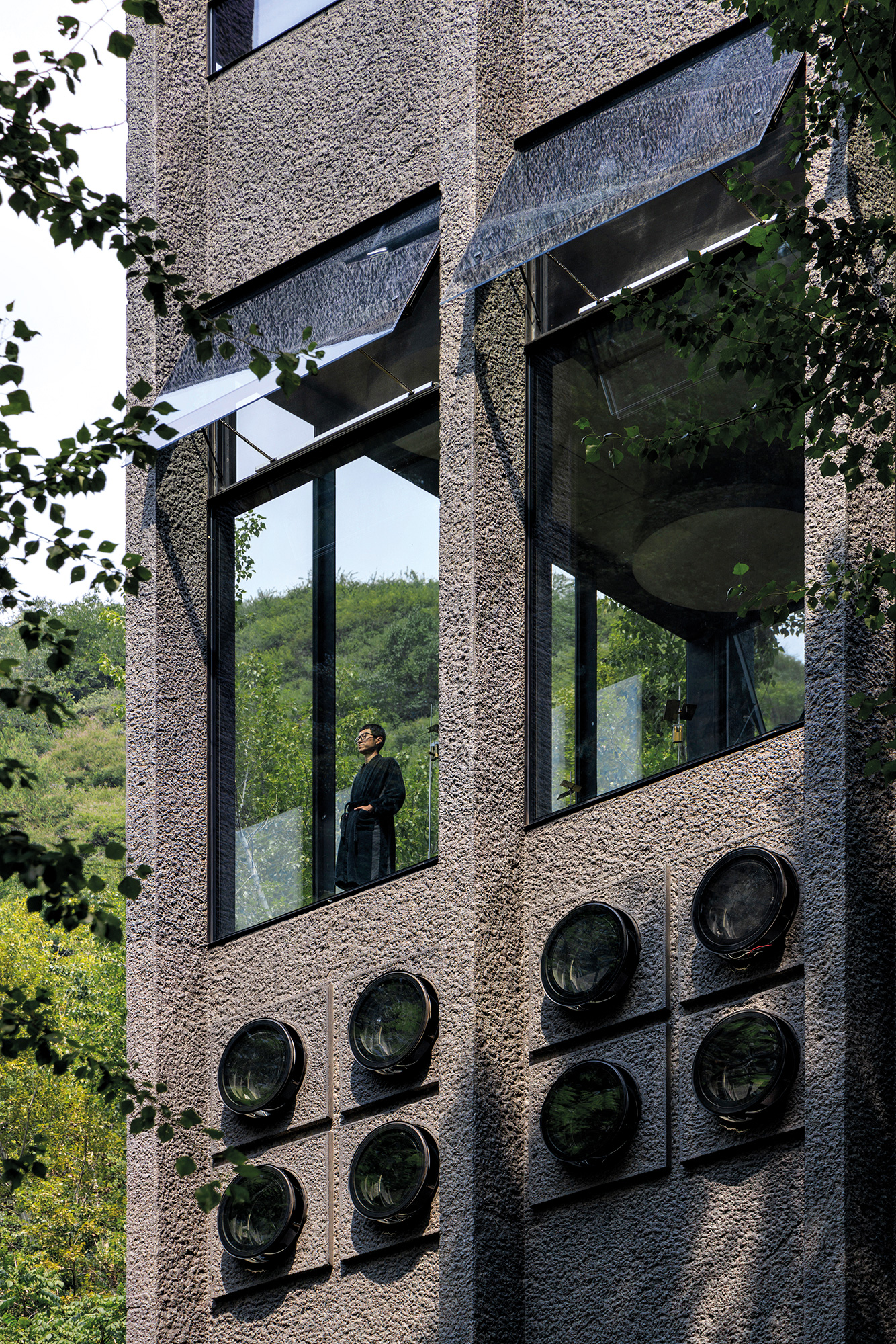 Um die Fassade zu stocken, wurde der Sichtbeton um 2–3 cm verstärkt. Eine dunkle Betonlasur greift den Farbton der Felsen auf.