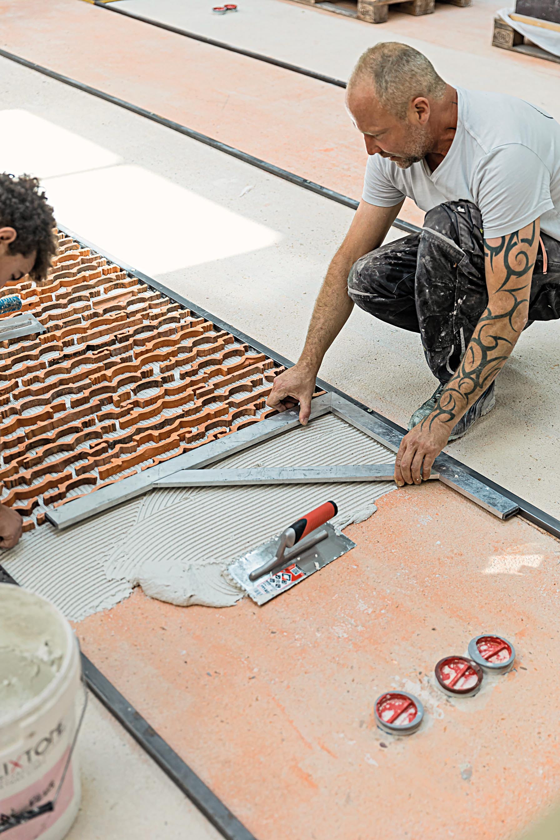 Damaged roof tiles above the hall were cut into strips and decoratively embedded in the terrazzo flooring. Others were crushed into brick dust and added to the wall render.