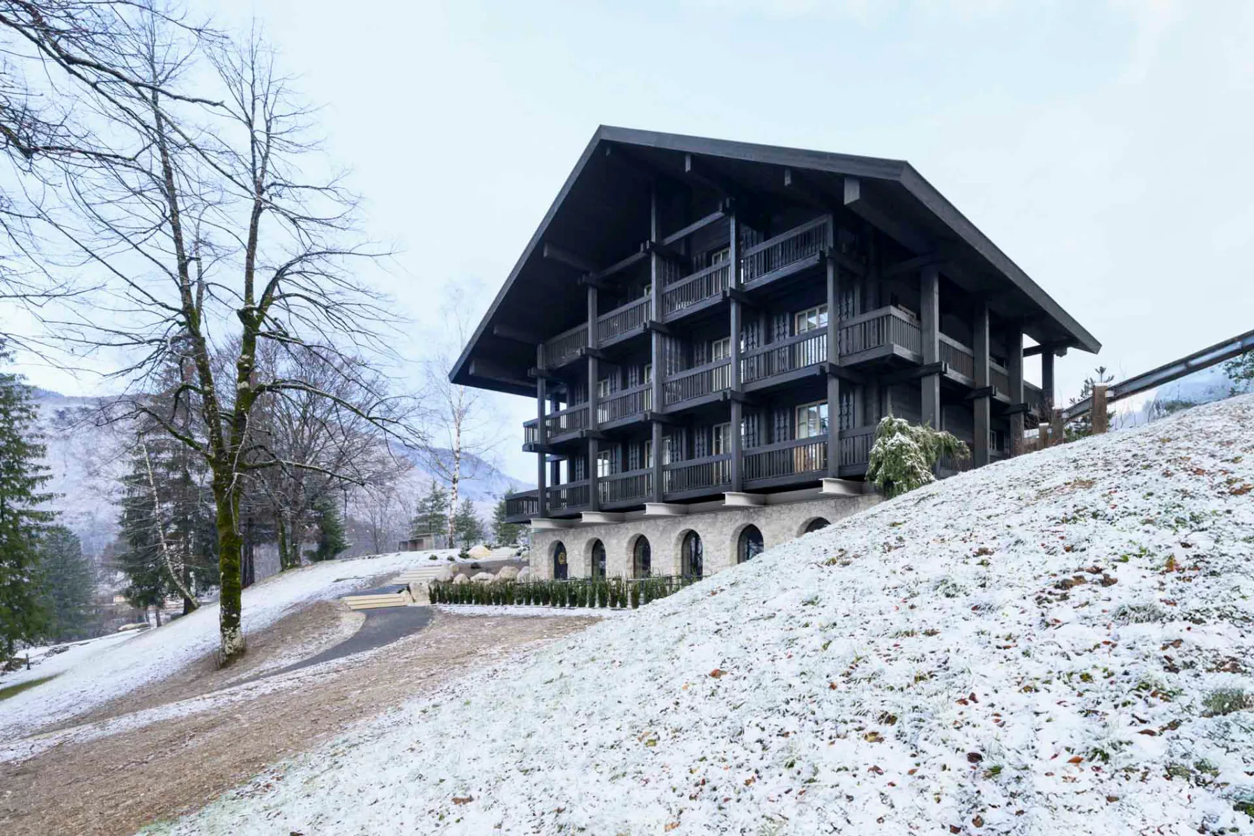 Die Villa Muhr steht auf einem Hanggrundstück am Ortseingang von Ribčev Laz. Von der Talseite aus ist die Gliederung des Gebäudes in einen Sockel aus Stein und einen Aufbau aus Holz gut zu erkennen.