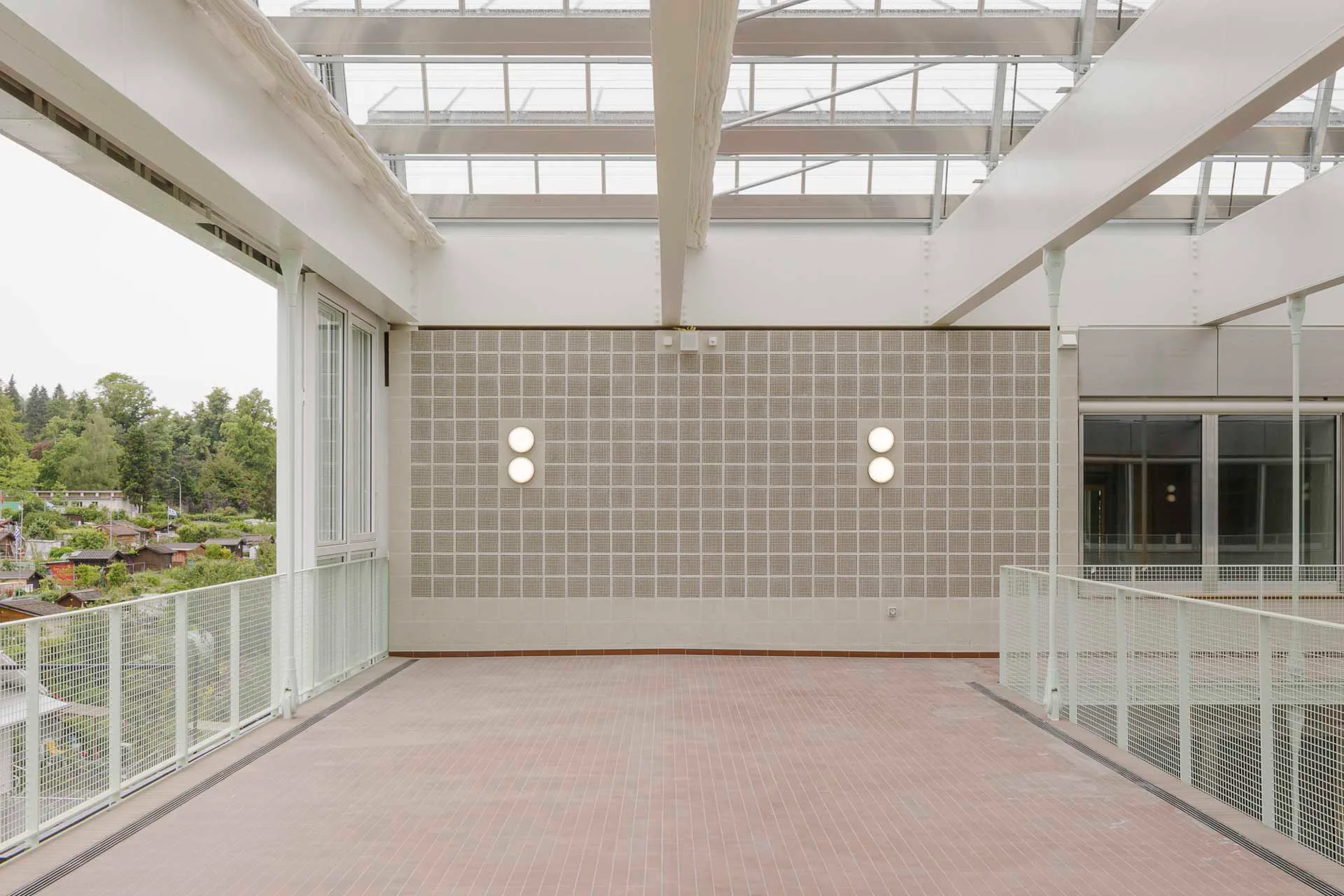 Über große Schiebetore lässt sich das Atrium im Sommer ganztägig zum benachbarten Park hin öffnen.