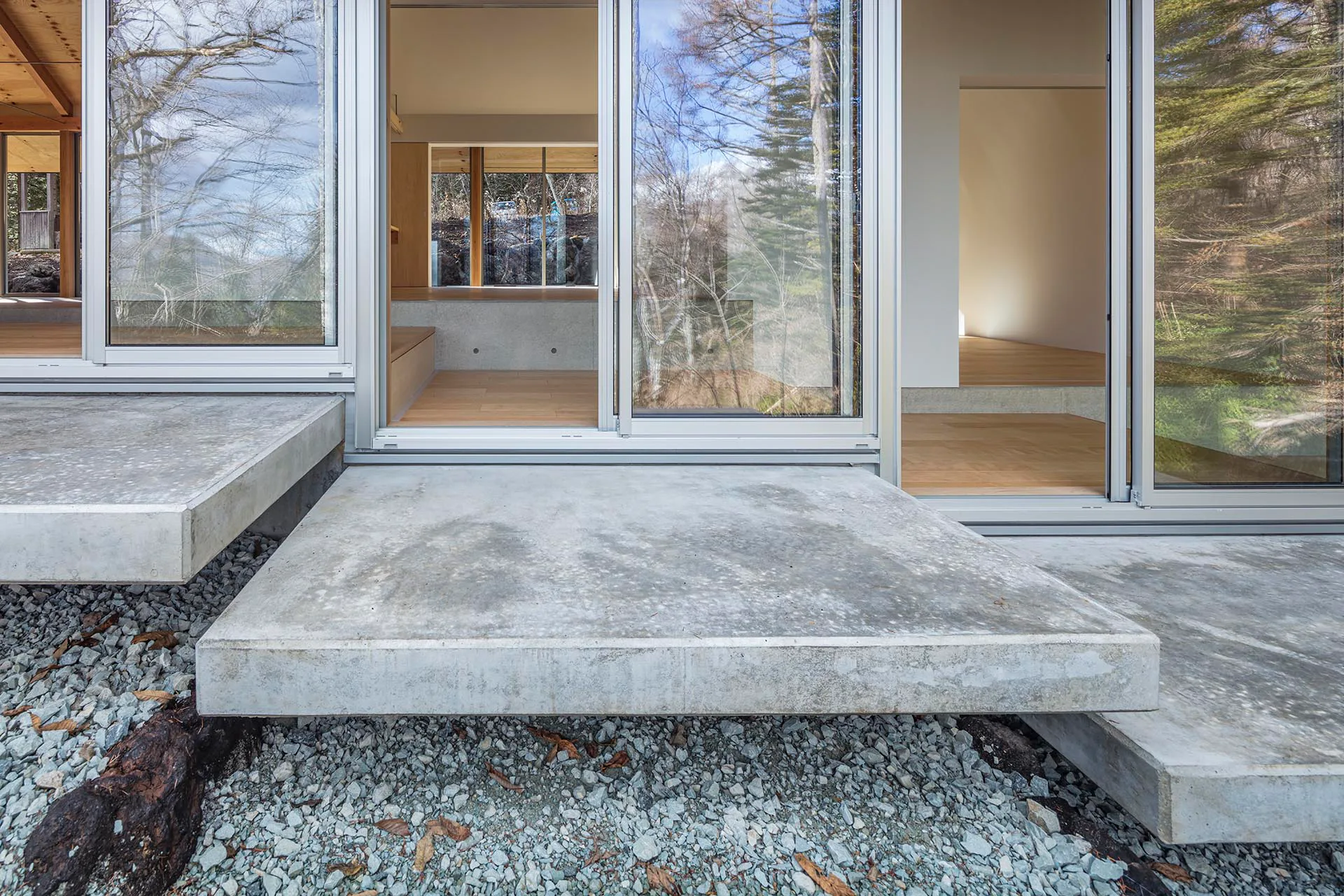 Weit auskragende Betonplatten betonen die Höhenabstufung des Hausgrundrisses zusätzlich.