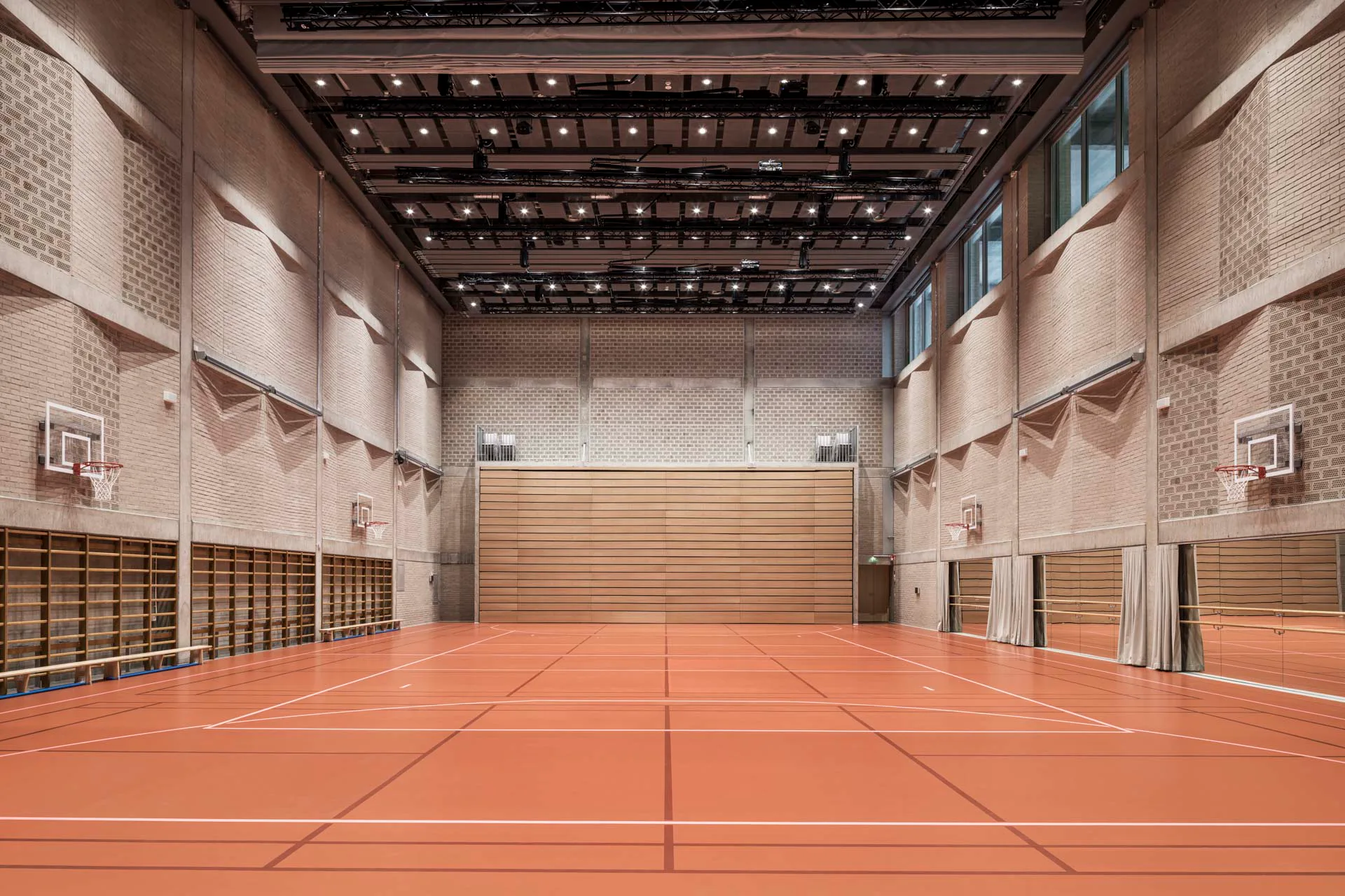 Die Turnhalle ist auch für Veranstaltungen nutzbar. Ihre gefalteten Ziegelwände sind schalltechnisch optimiert.