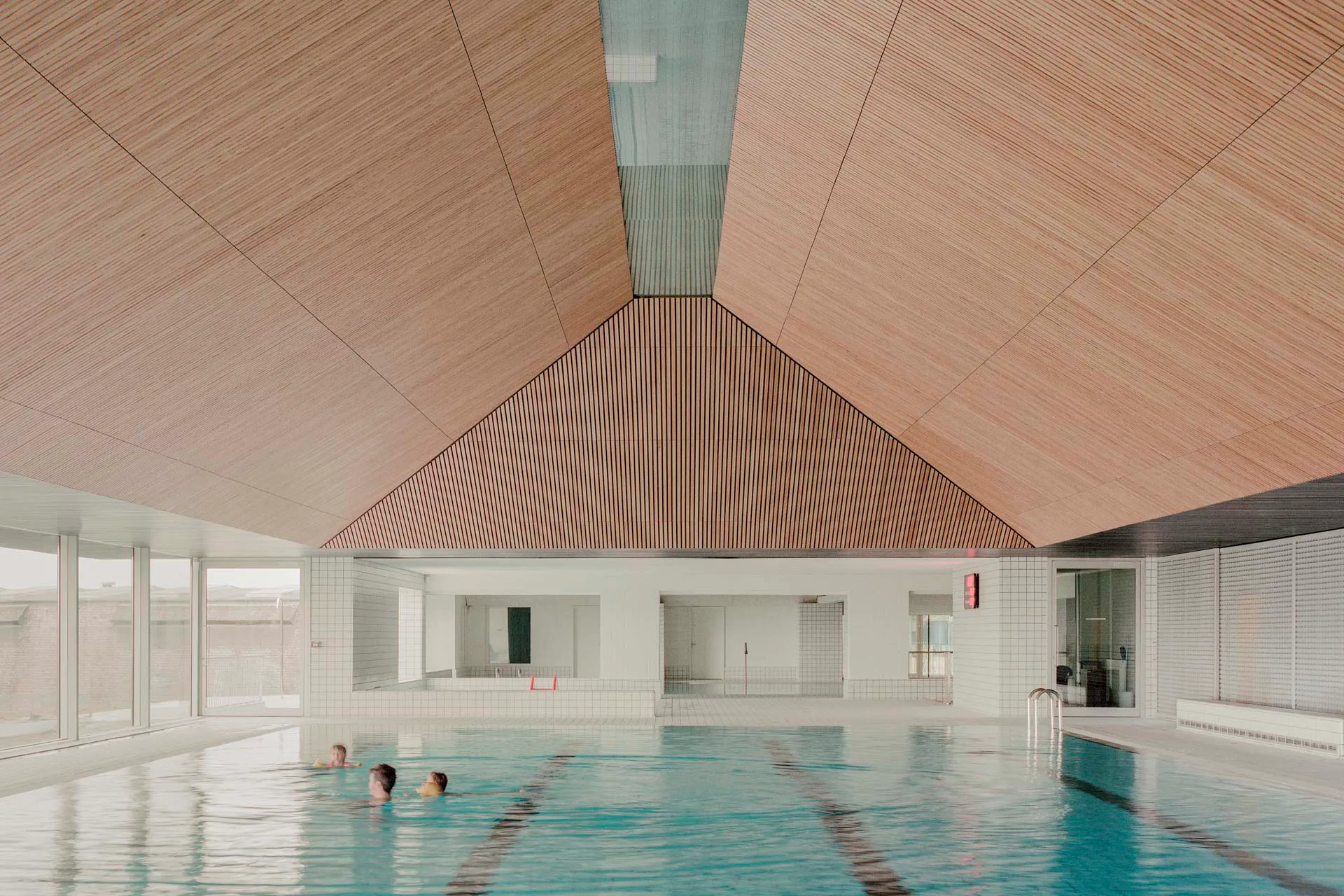 Über dem 25-Meter-Becken verdeckt eine Holzdecke die großen Fachwerkbinder des Dachs.