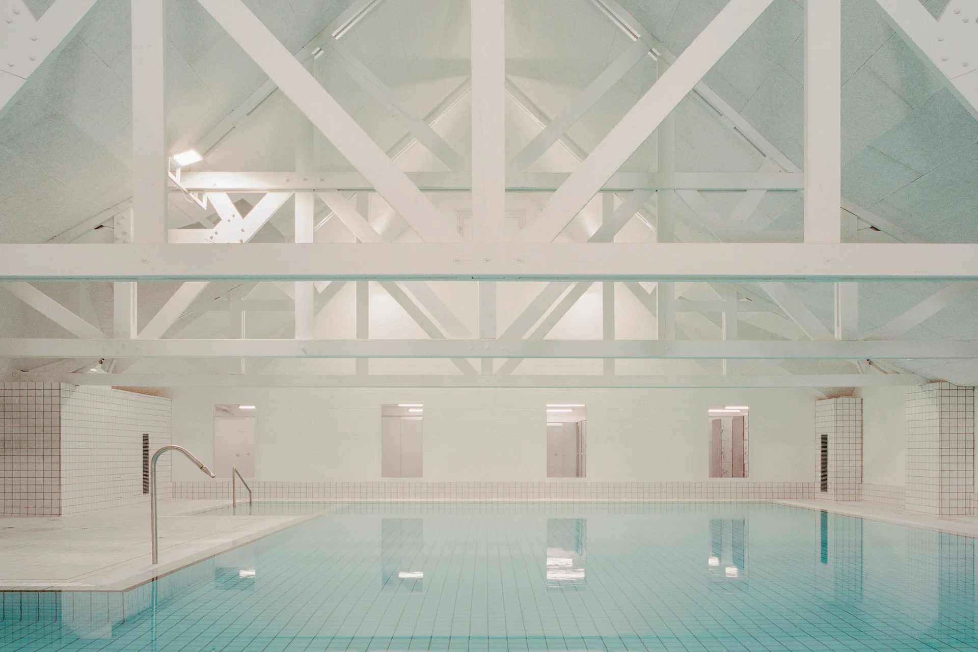 Rund um das alte Schwimmbecken sind Wände, Böden und Decken ganz in Weiß gehalten.