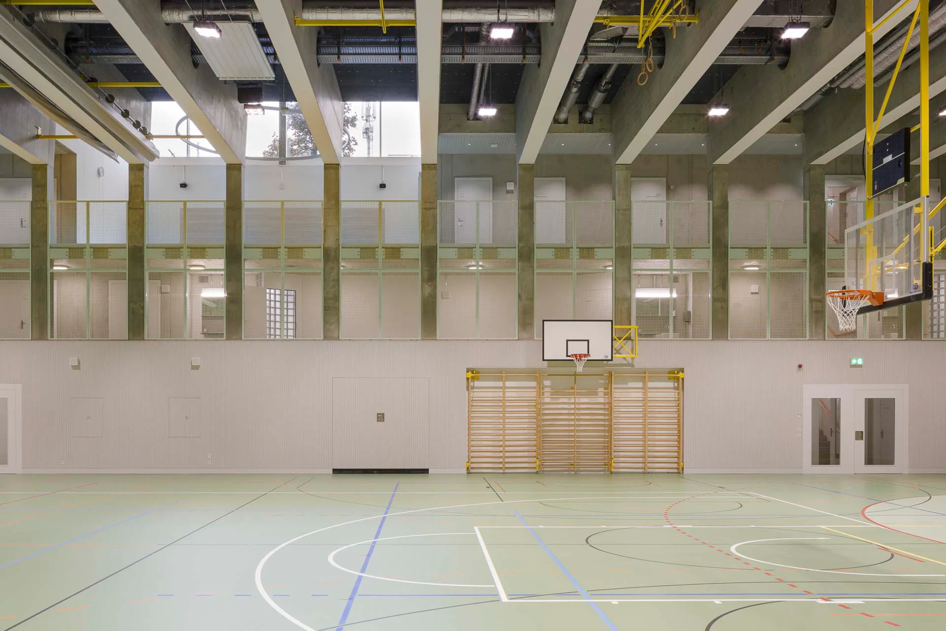 Die Sporthalle liegt drei Ebenen unter der Erde. Dennoch erhält sie über einen zweigeschossigen Raum auf der Nordseite Tageslicht.