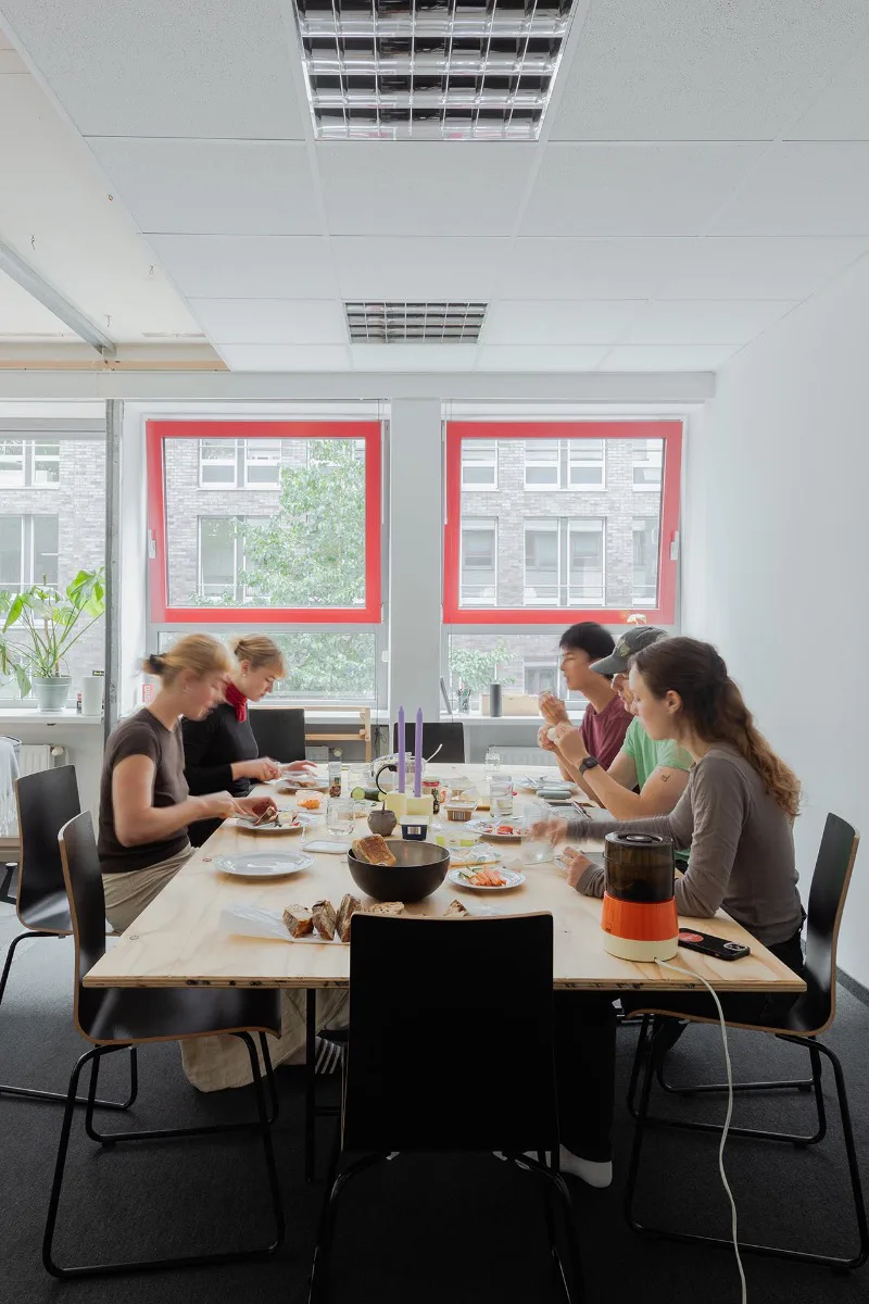 Der große Tisch im Gemeinschaftsraum bietet Platz für gemeinsames Mahlzeiten oder Co-Working-Sessions.