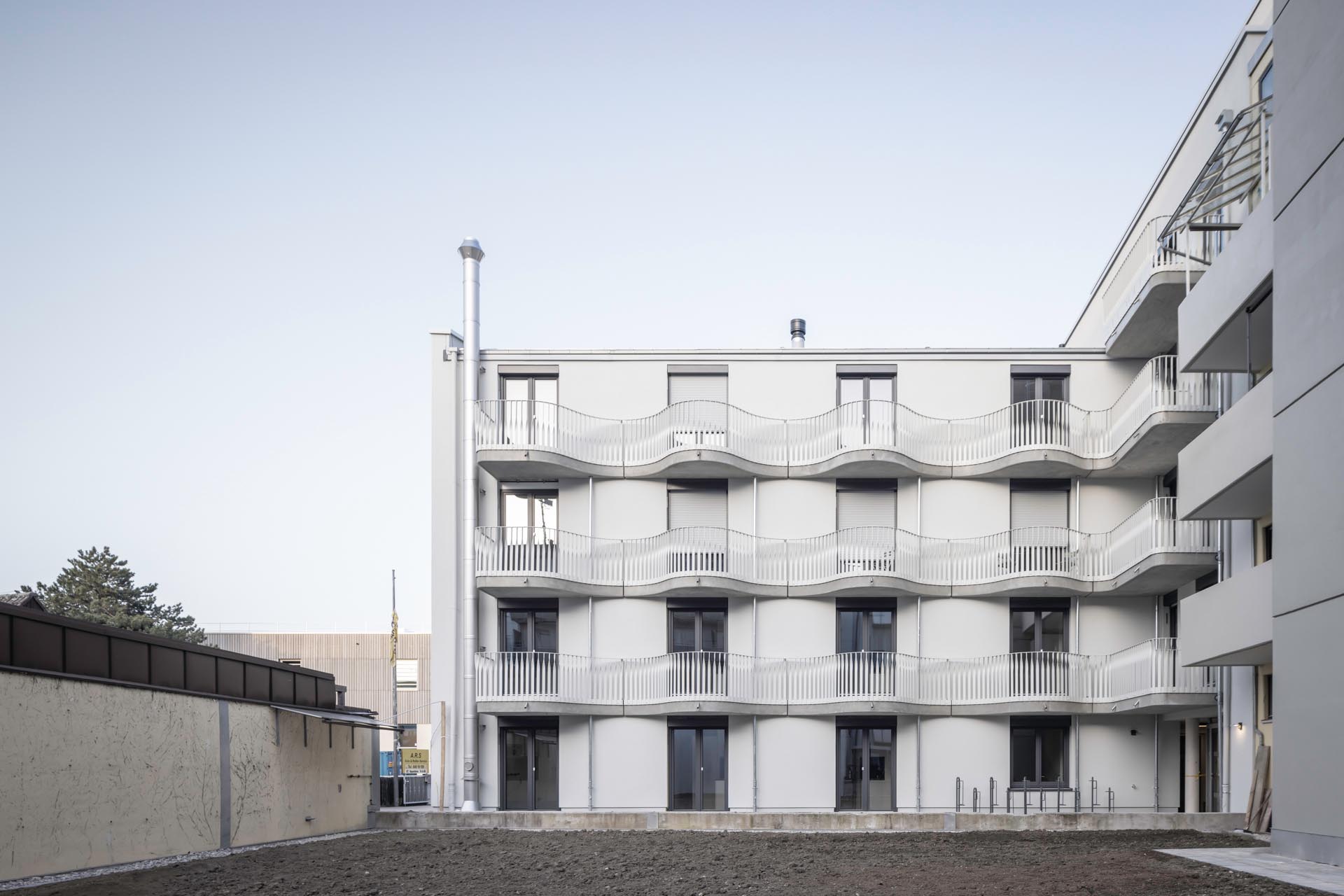 Geschwungene Balkone mit filigranen, in sich verdrehten Stabgeländern akzentuieren die Fassade zum Innenhof.