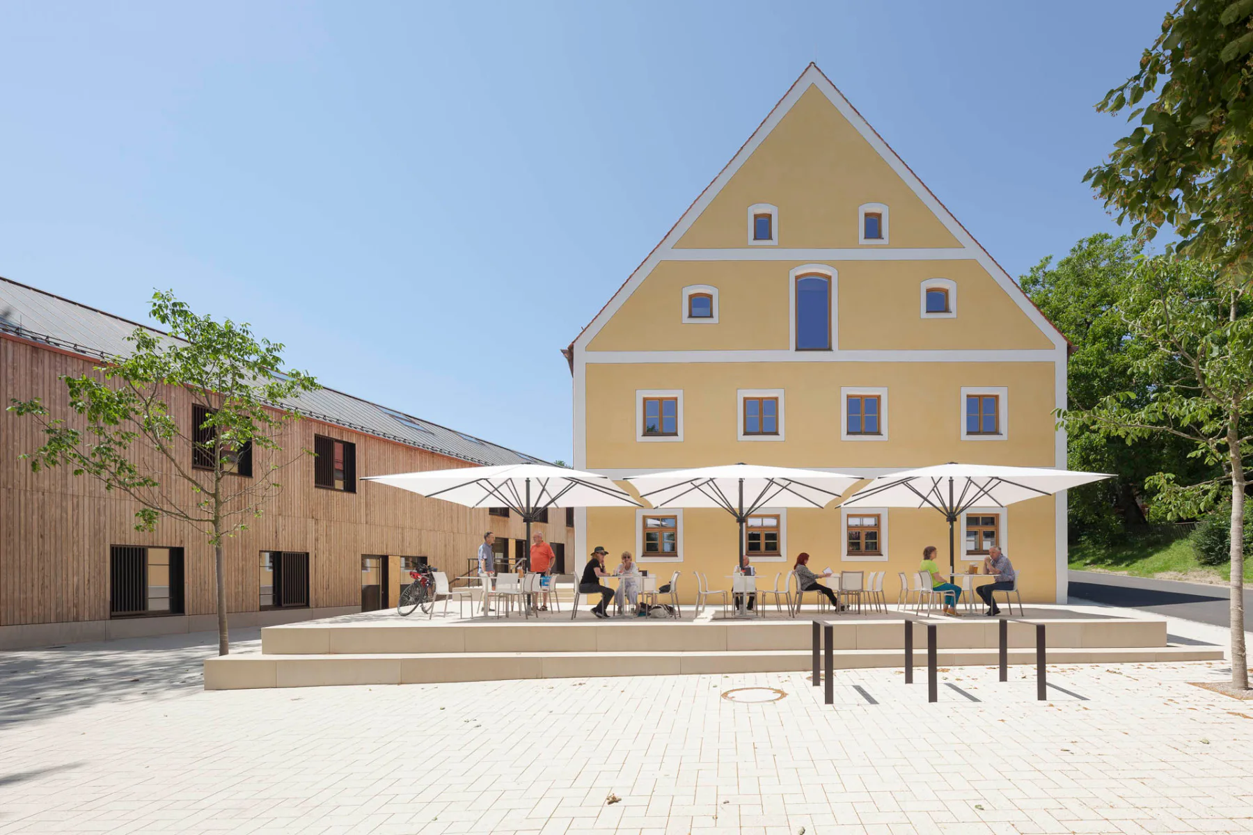 Der Neubau mit Rathaus und Gemeindebücherei steht der ehemaligen Tafernwirtschaft gegenüber, in die unter anderem wieder eine Gastronomie eingezogen ist.