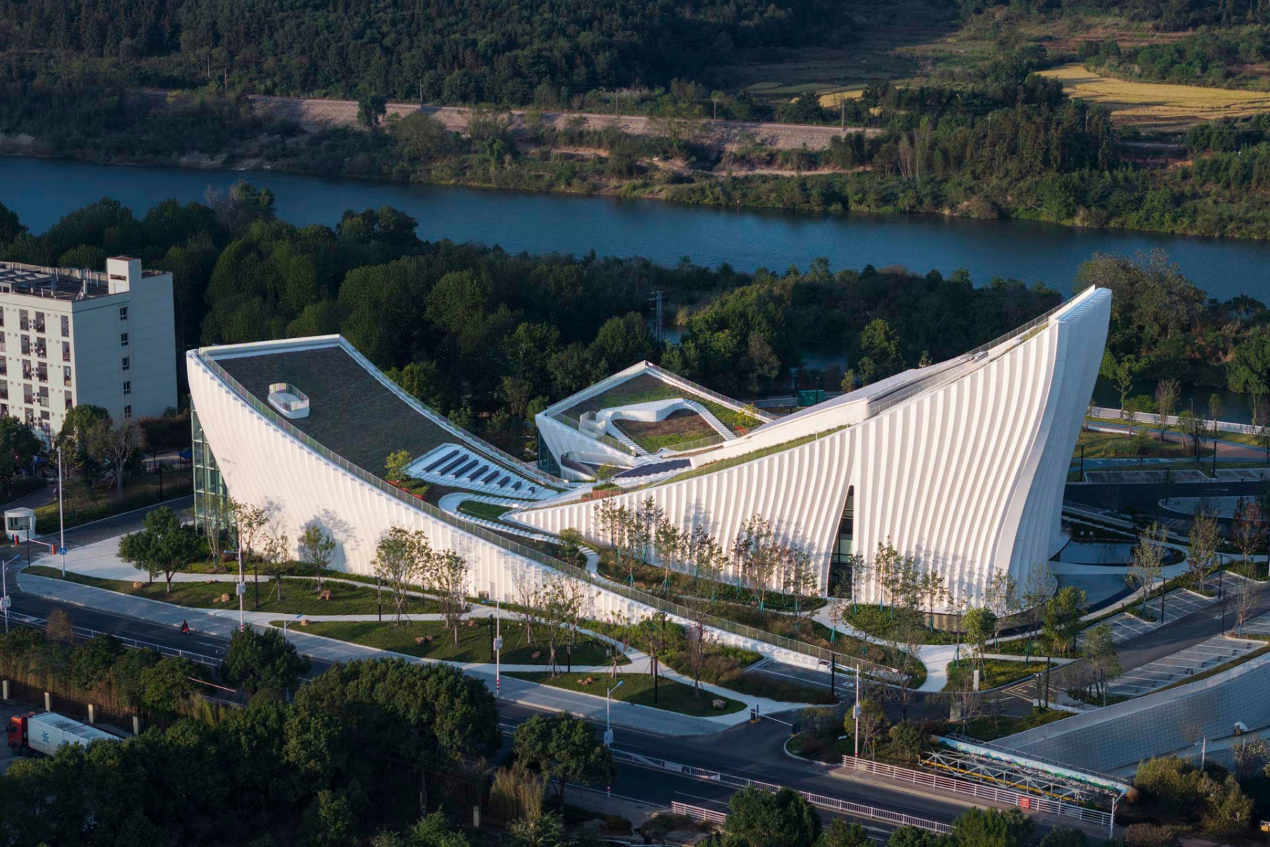 Drei wechselseitig geneigte Baukörper mit Gründächern beherbergen das neue Firmenmuseum. Die weitgehend geschlossene Gebäudehülle ist mit gefalteten Betonelementen verkleidet.