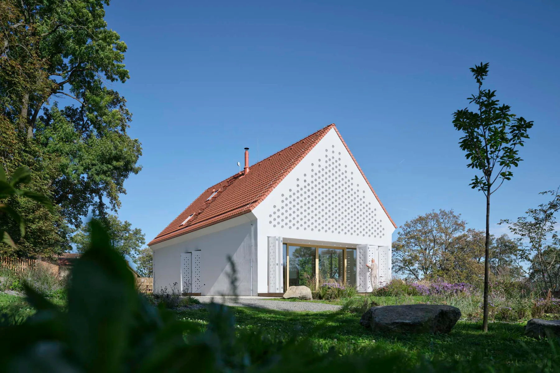 Die perforierte Fassade orientiert sich an den hölzernen Schlagläden traditioneller Bauten.
