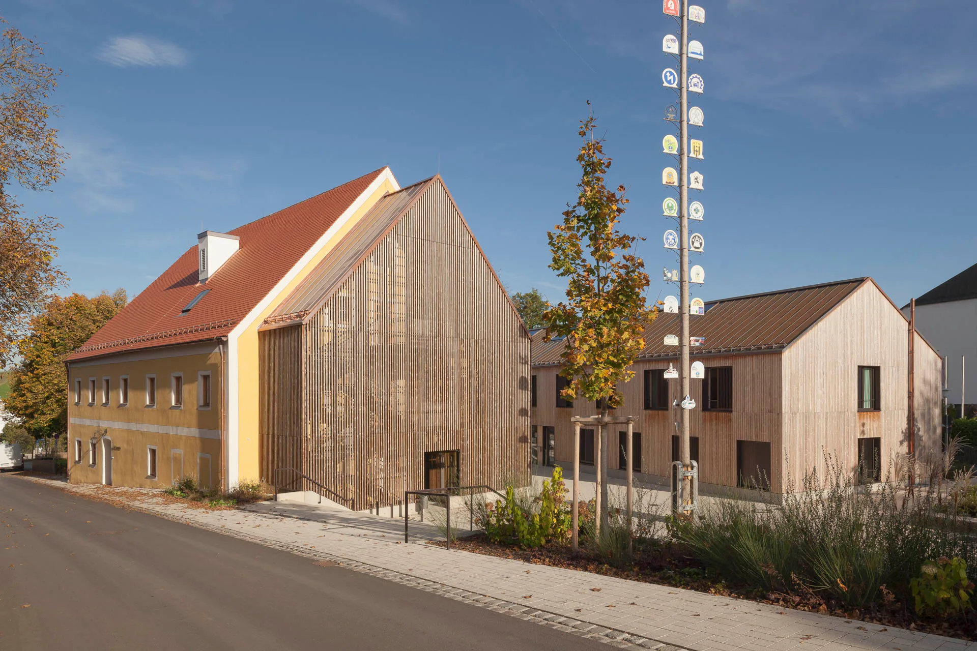 Die Erschließung der Obergeschosse des Bestands verbirgt sich in dem mit Holzlatten bekleideten offenen Anbau, der an eine sehr schmale Scheune erinnert.