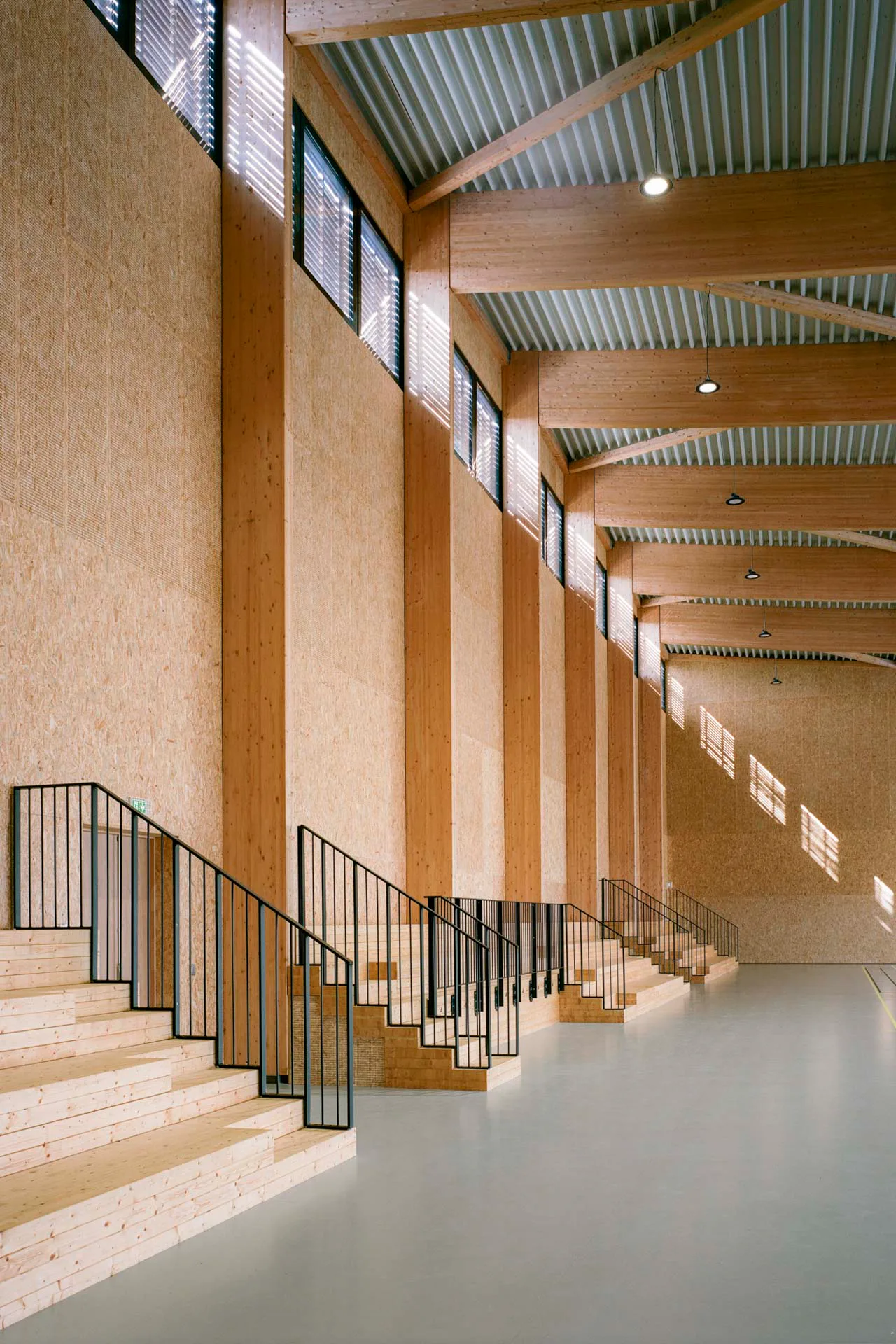 Die Materialpalette in den Innenräumen ist denkbar einfach: Stäbchenparkett, Trapezblechdecken, OSB-Platten und unverputztes Mauerwerk prägen die Räume.