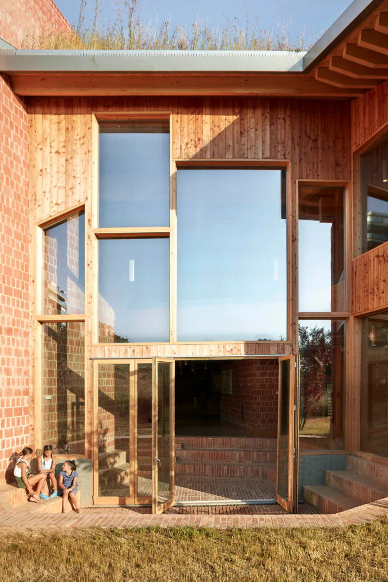 Eine Fassade ohne überflüssige Details: Holz und Terrakottaziegel charakterisieren die äußere Erscheinung der Schule.