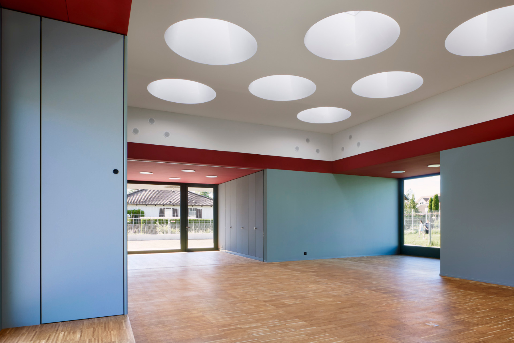 Zwölf Flachdachfenster mit kreisrunden Deckenausschnitten bringen Licht in die zentrale Halle.