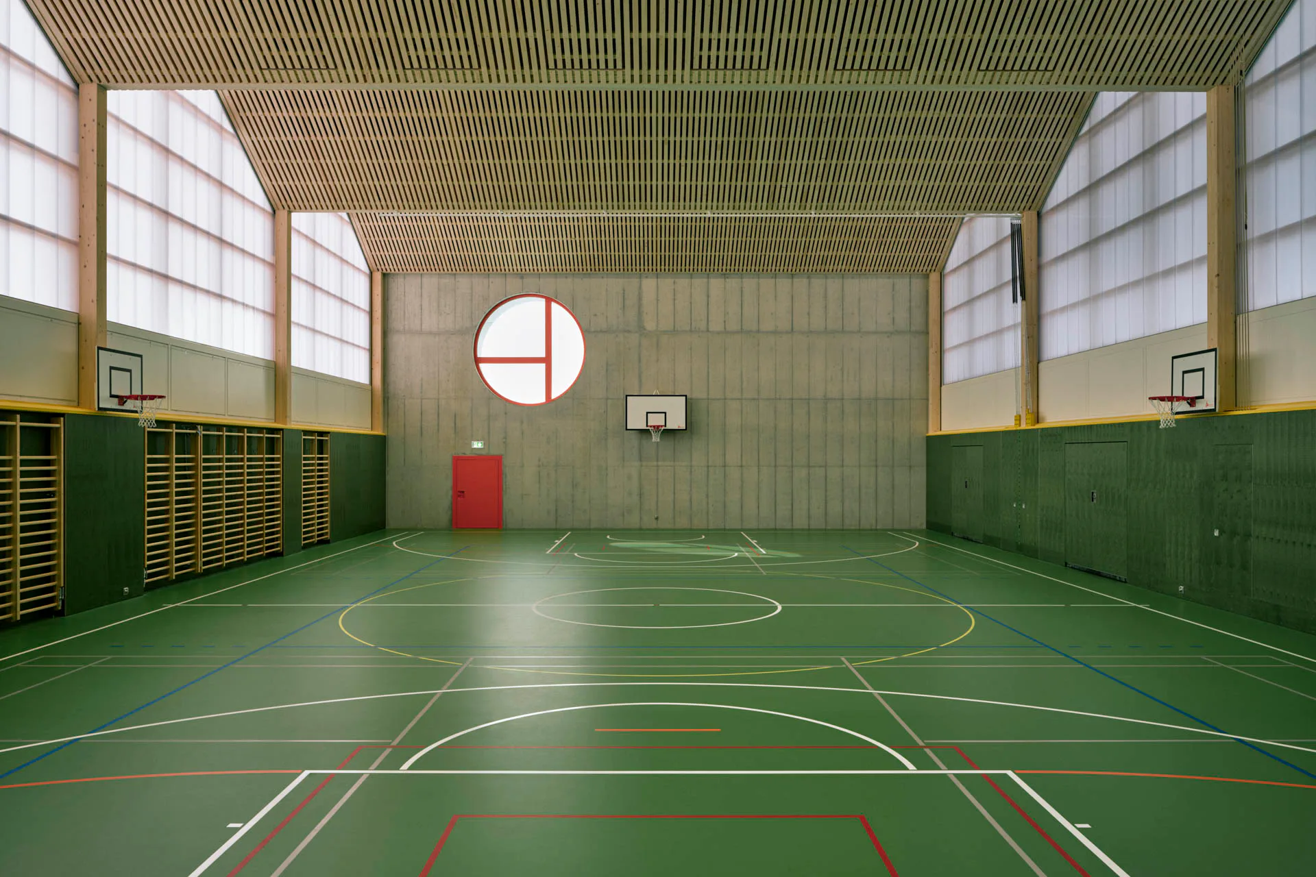 Zweischalige Kunststofffassaden filtern gedämpftes Tageslicht in die Turnhalle.