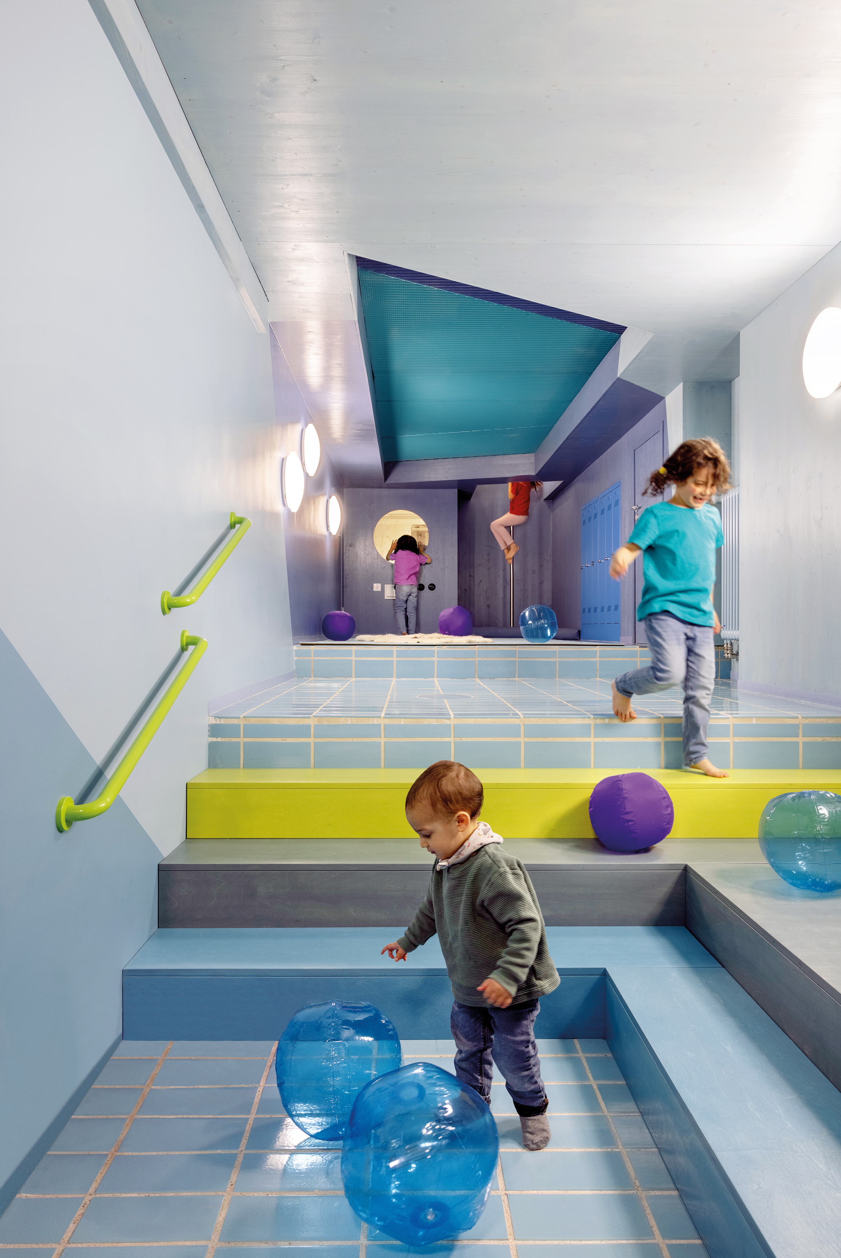 Das Schwimmbecken wurde für die Kita Hisa Malteser in eine Spielhöhle umgebaut. Über eine Rutschstange tauchen die Kinder in die abstrakte Unterwasserwelt ein.