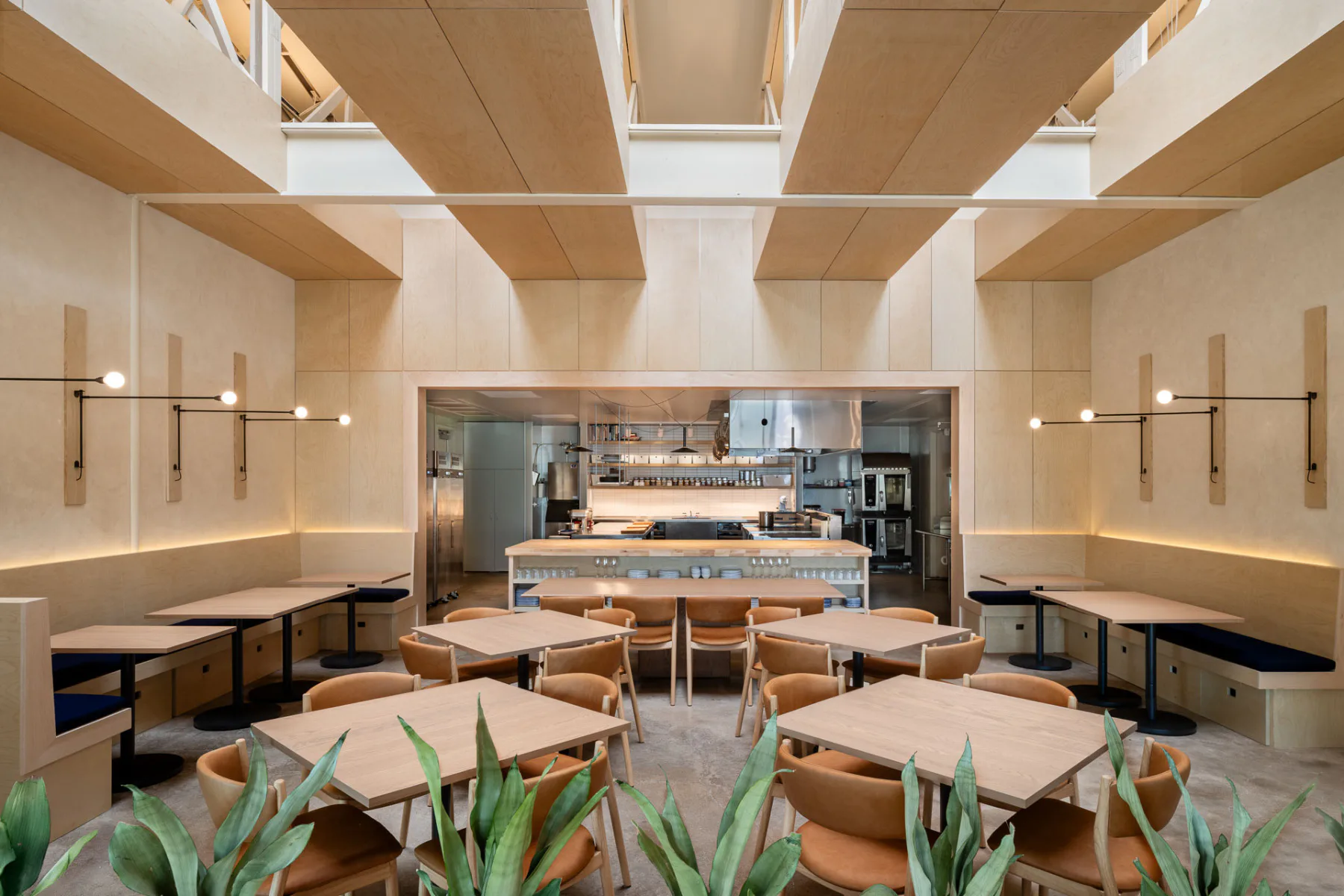 Das Restaurant entstand in einer umgebauten Metallwerkstatt. Die Küche im hinteren Bereich des Raums öffnet sich beinahe in voller Breite zum Gastbereich.