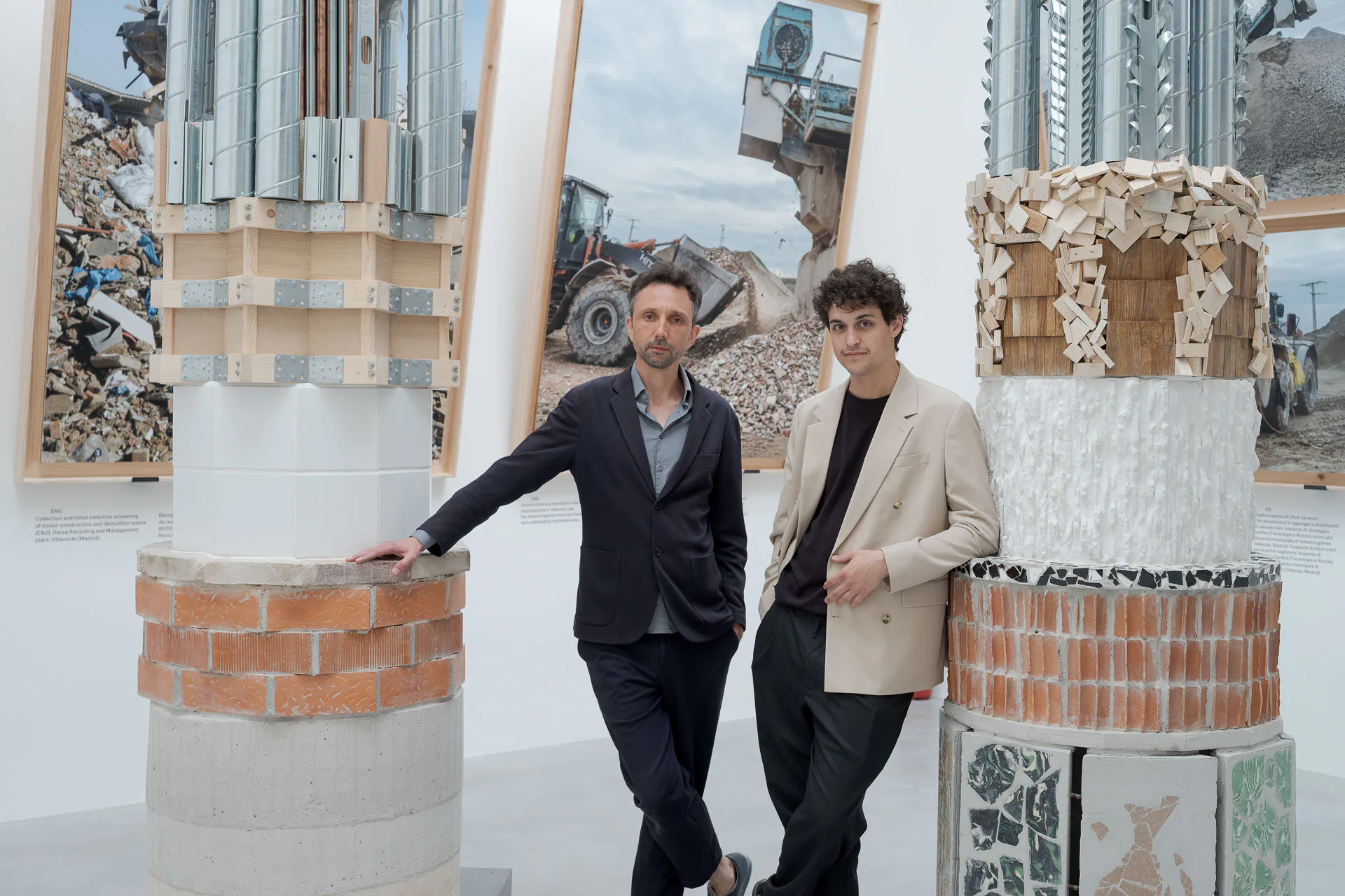 Roi Salgueiro (links) und Manuel Bouzas (rechts) thematisieren die Dekarbonisierung der Baubranche. Die Säulen zeigen Materialien und ihre Rückstände.