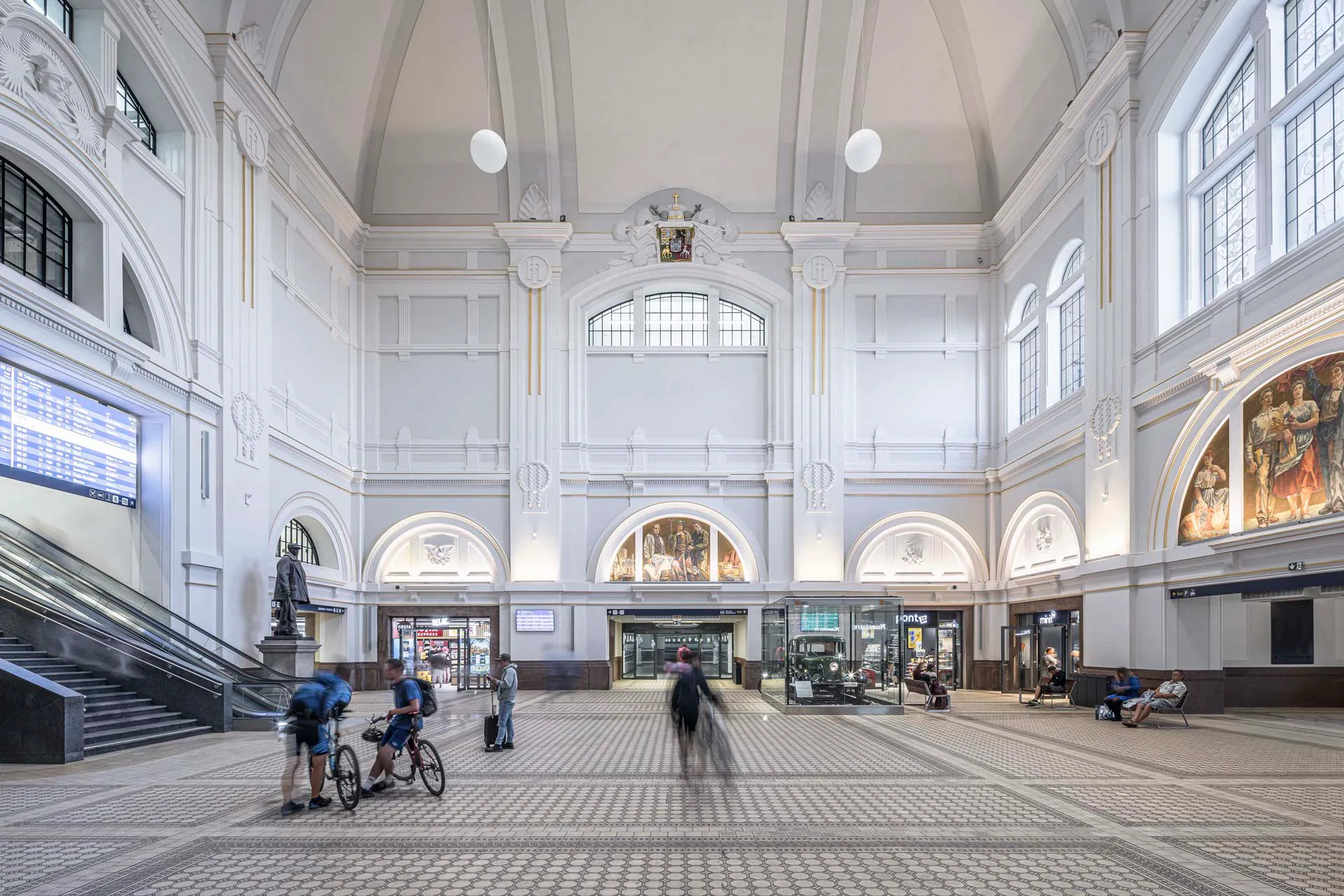 Grau-, Weiß- und Cremetöne prägen die Halle, ergänzt durch RAKO-Fliesen im historischen Muster.