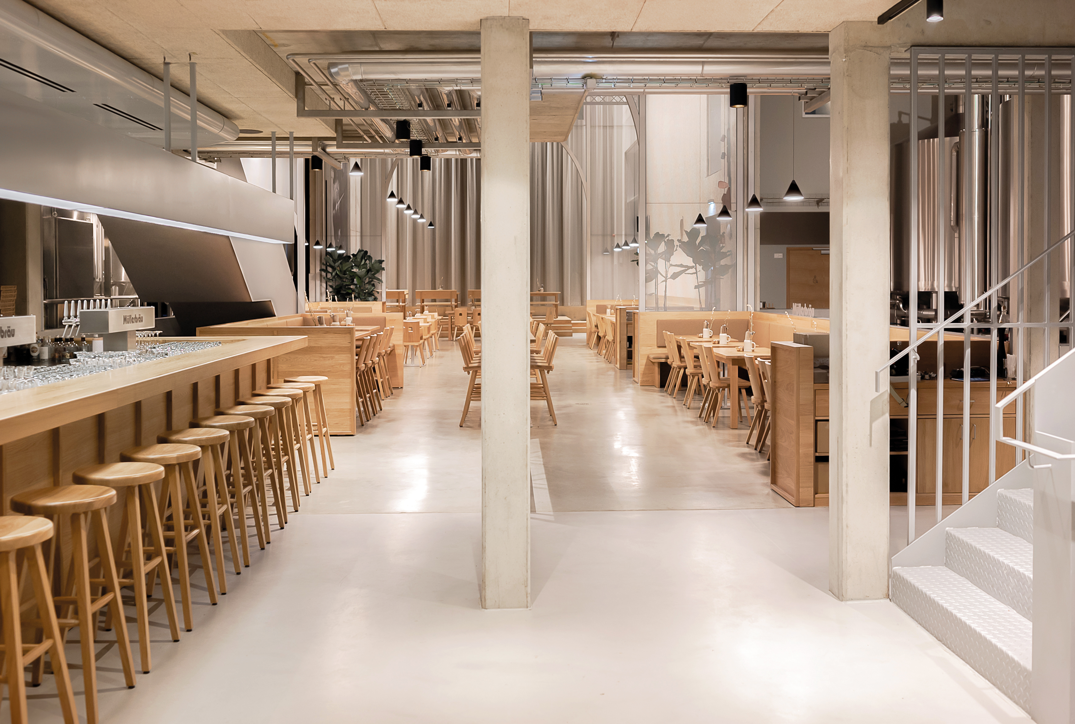 A longitudinal bar counter made of oak marks the beginning of the restaurant area. The double flight staircase across from it leads to the gallery seating.