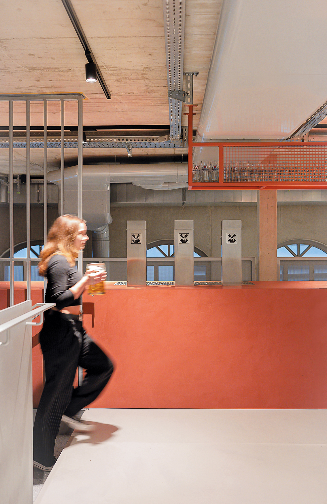 The upper floor bar displays a striking colour accent, recalling the beige red hues of the Müllerbräu brand.