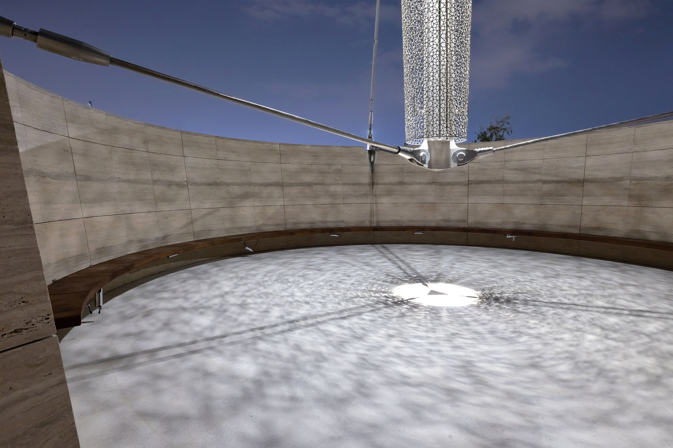 The 39 m tall minaret, a tensegrity structure, hovers above the ground by 2.30 m. It is suspended from the surrounding perimeter wall, circular in plan, by three steel cables.