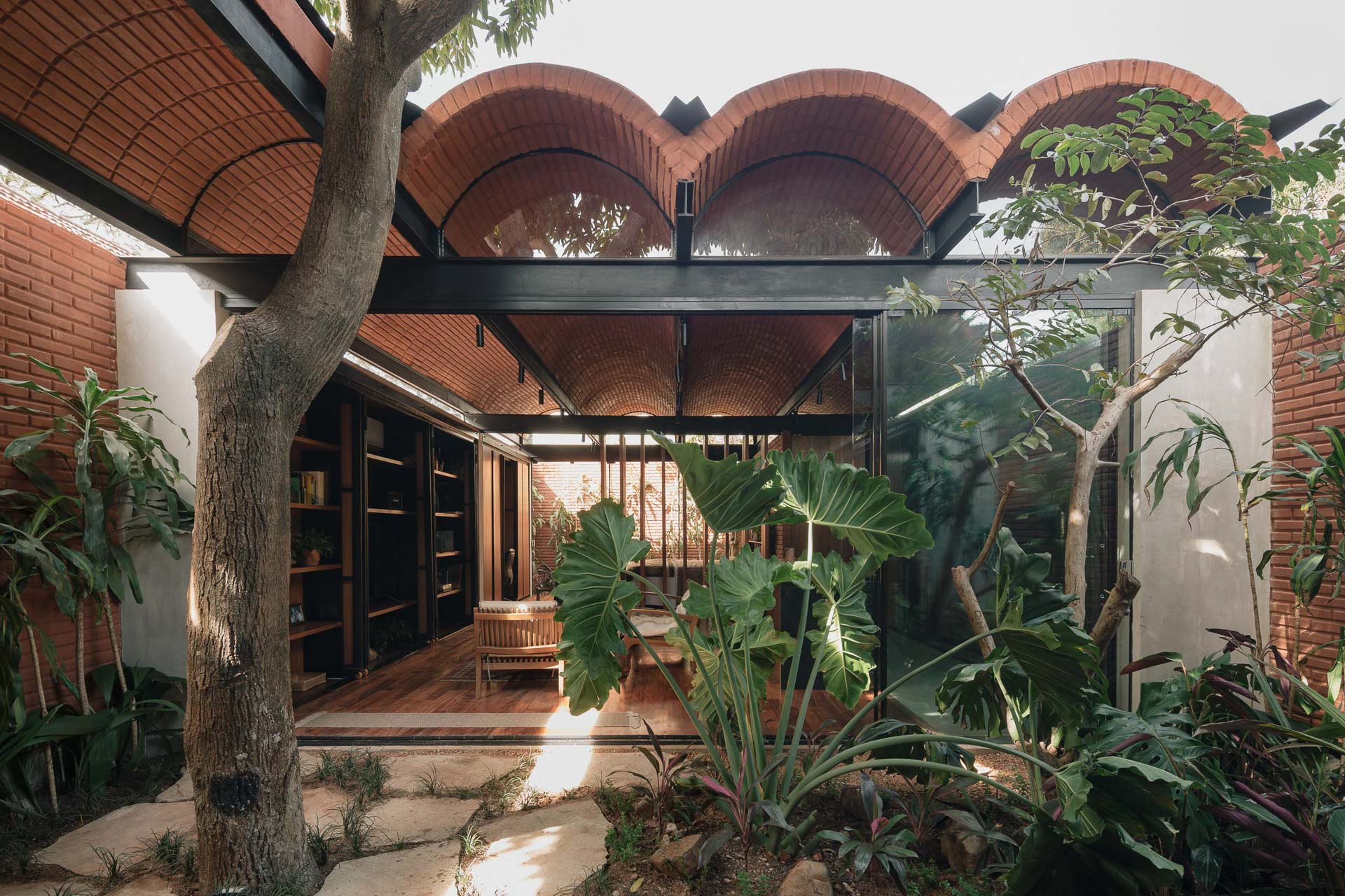 Die Casa Intermedia von Equipo de Arquitectura steht auf einem schmalen Handtuchgrundstück in Asunción, der Haupstadt von Paraguay. Wände und Dachschalung des Gebäudes bestehen aus luftgetrockneten Lehmziegeln.
