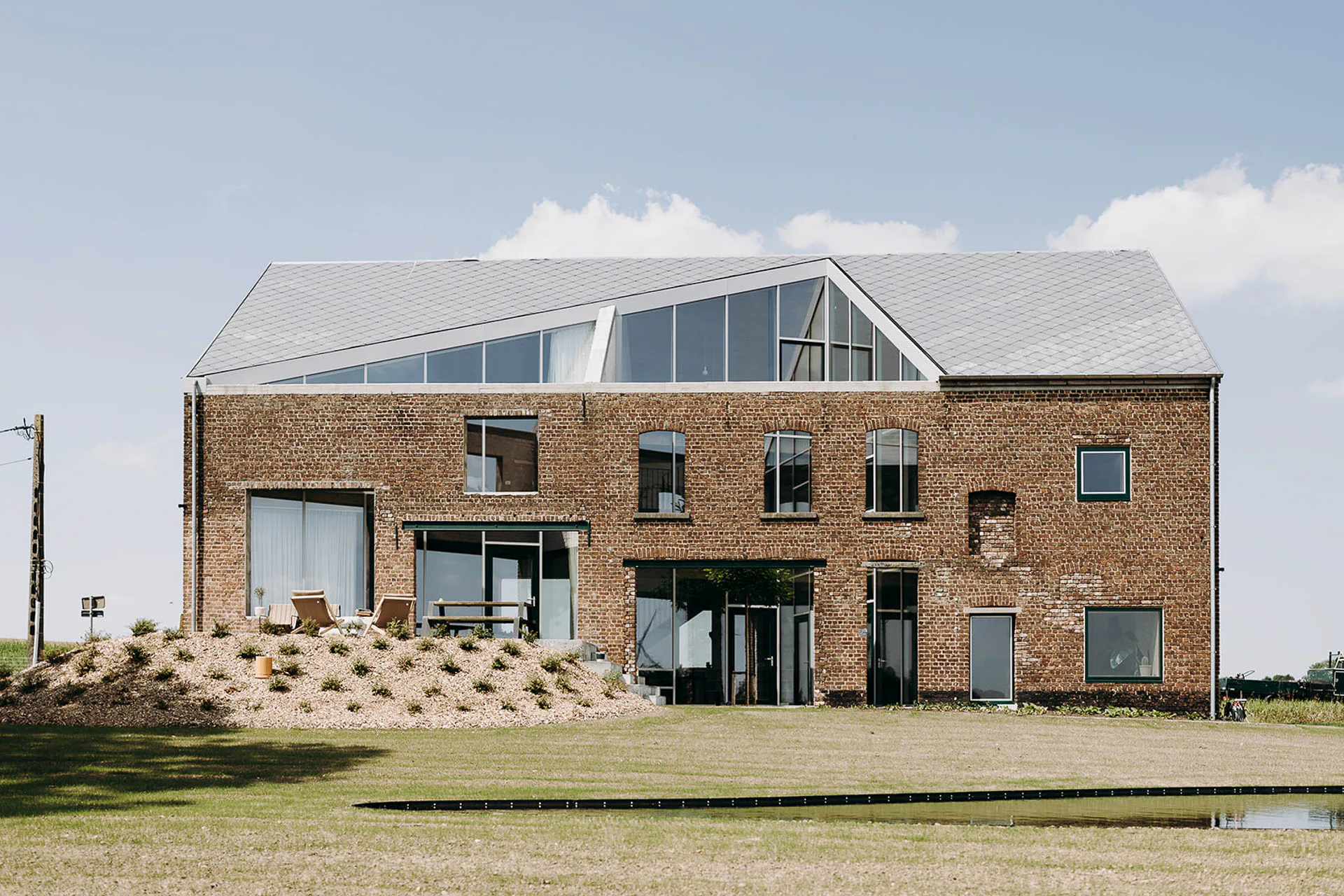 Ein dreieckiger Einschnitt im Dach charakterisiert das Lyco Haus bei Brüssel von Oyo Architects.