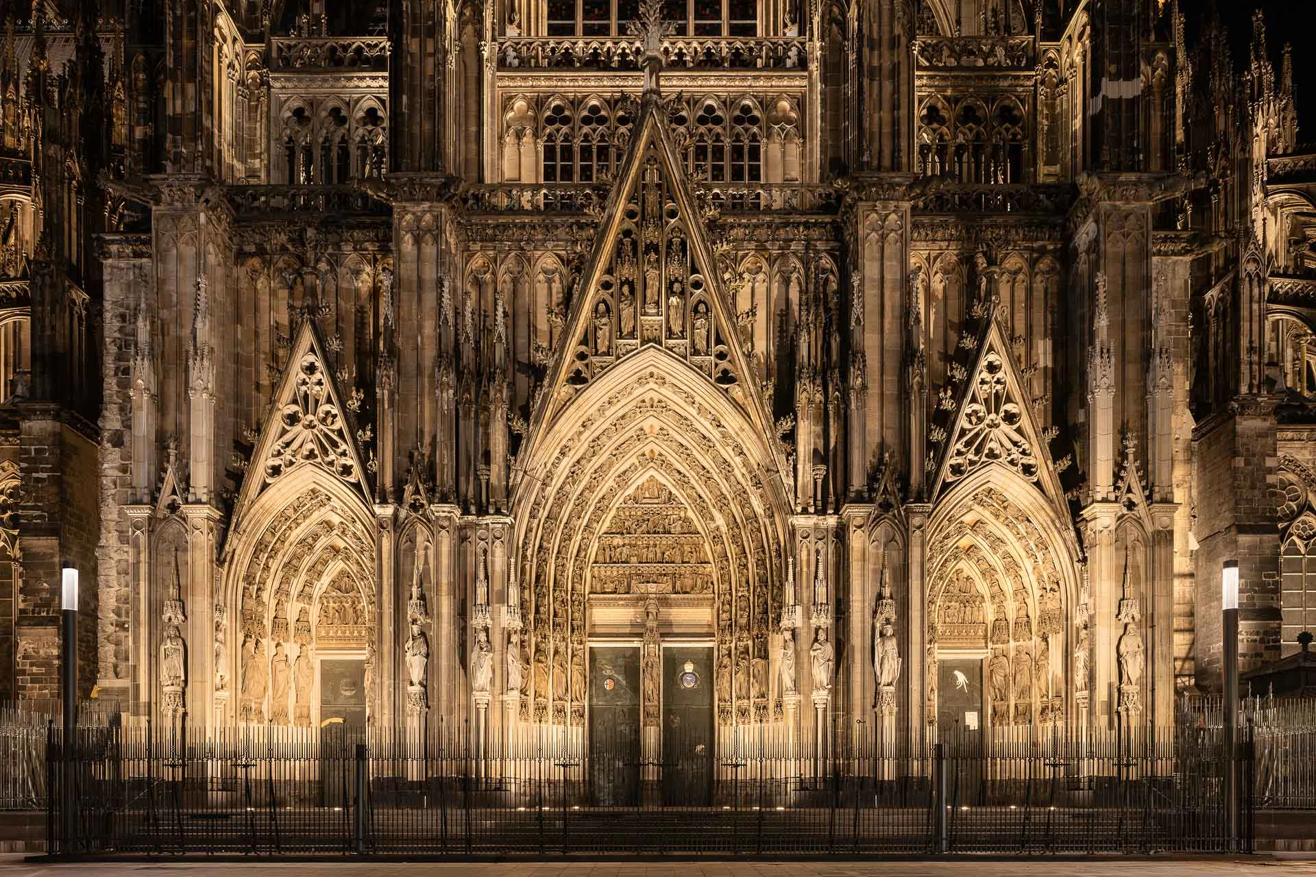 Sonderleuchten vor den Eingängen von West-, Süd- und Nordfassade beleuchten die Verkehrsflächen und akzentuieren zugleich dezent den Reichtum der gotischen Ornamente.