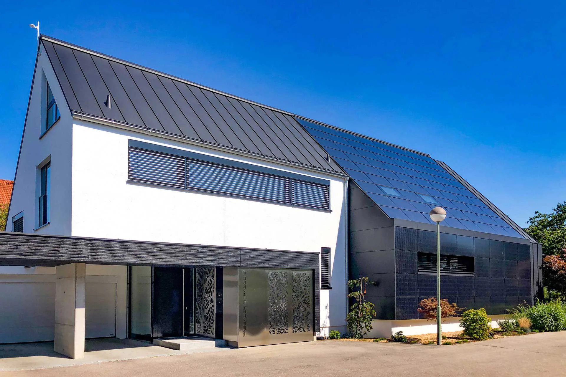 Die große PV-Anlage integrierten die Planer flächenbündig in Dach und Fassade – ganz im Einklang mit den klaren, eleganten Formen und der reduzierten Materialauswahl.
