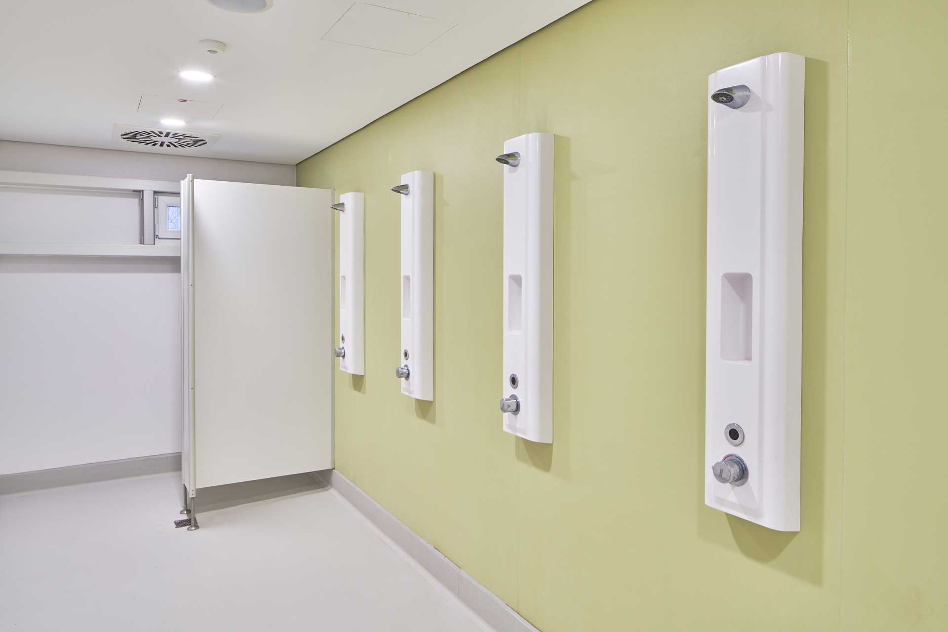 Einfach ausgestattete Sammeldusche und Einzelkabine mit abgehängter Decke.