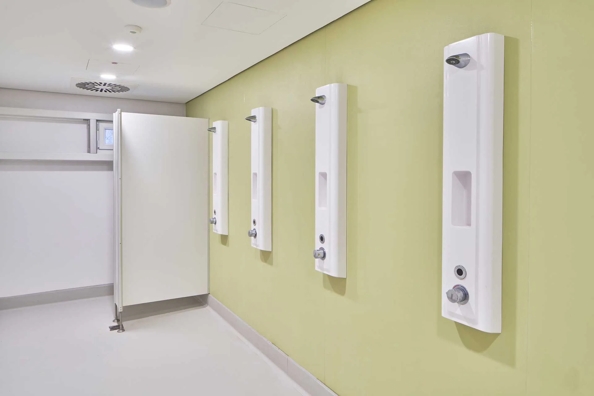 Einfach ausgestattete Sammeldusche und Einzelkabine mit abgehängter Decke.