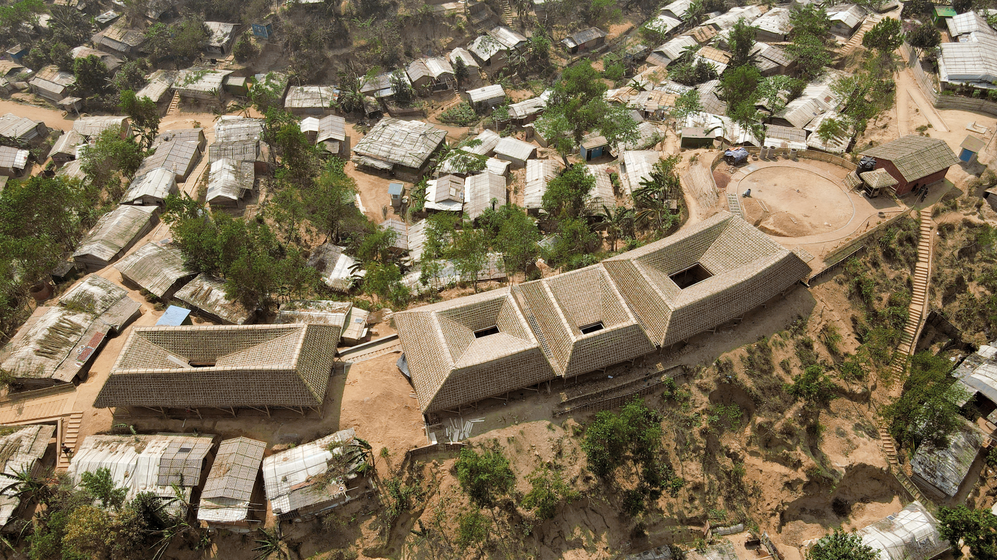The Rohingya Cultural Memory Centre stands on a small rise within the camp. Its four roofs are thatched with palm leaves.