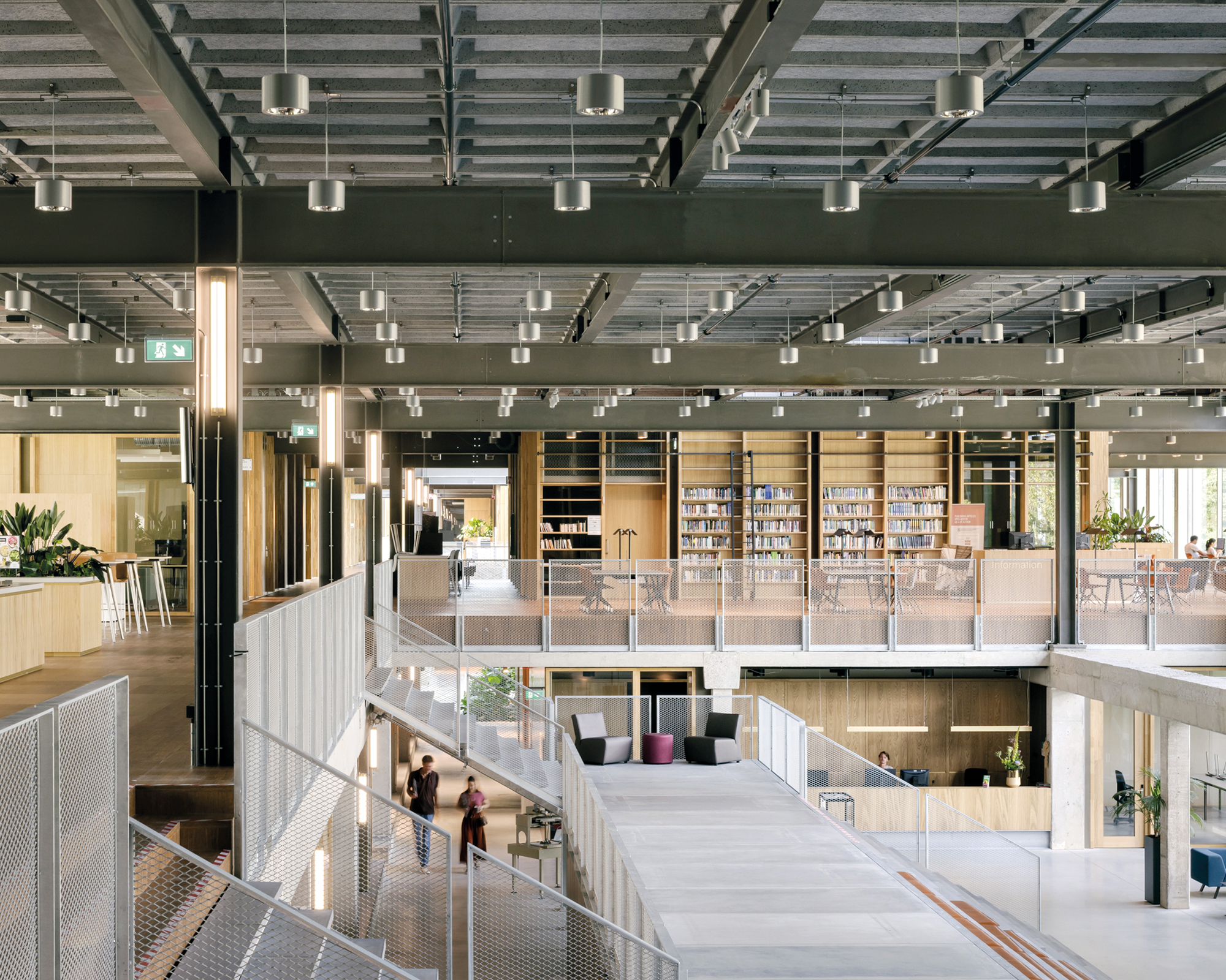 Gestaffelte Aufenthaltszonen in der lichtdurchfluteten Eingangshalle laden zu Begegnungen ein. Um sie herum gruppieren sich kommunikative Bereiche wie das Studierendenforum oder die Bibliothek.