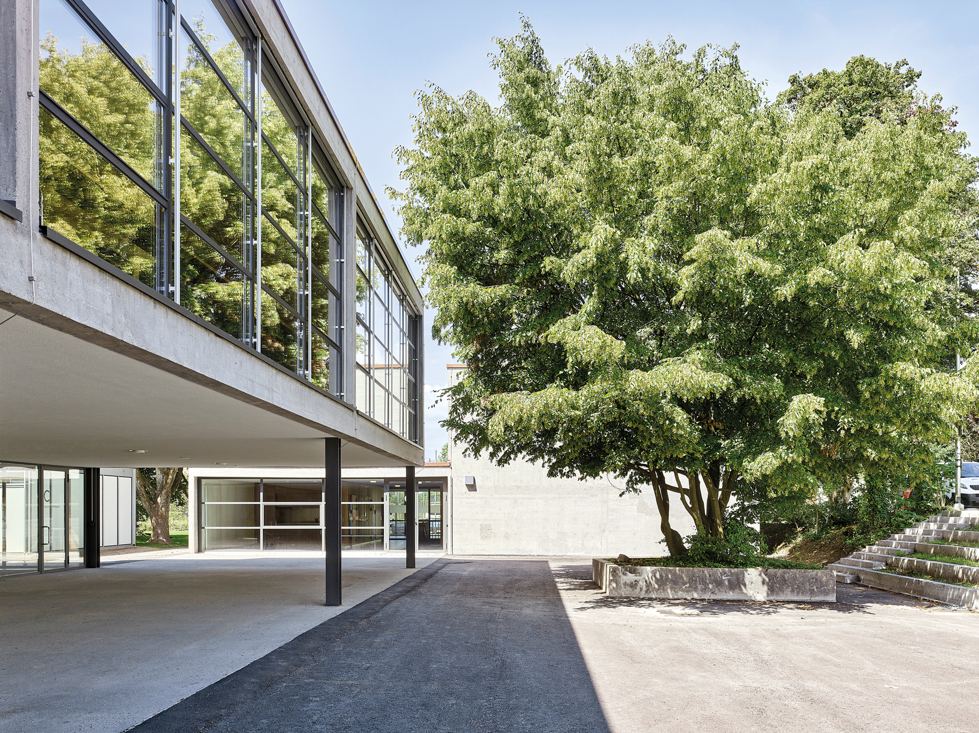 Gymnasium, pavilion, and the classroom building are organised according to a strict orthogonal grid. Large scale upper floor glazing and the open ground floor provide the school with lightness and transparency.