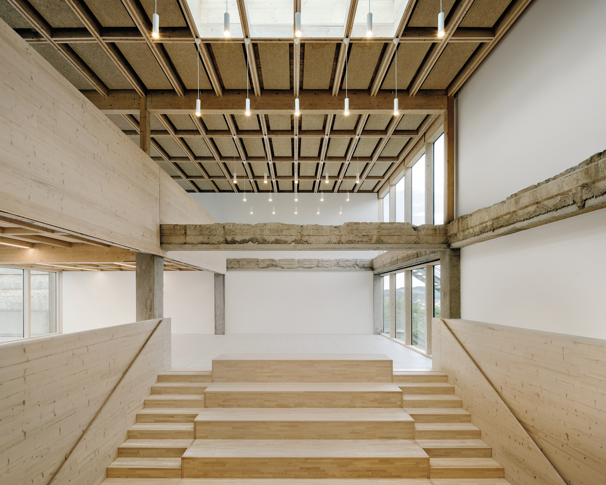 Eine dreigeschossige Halle mit breiter Sitztreppe dient nun als zentraler Verteilerraum der Schule.