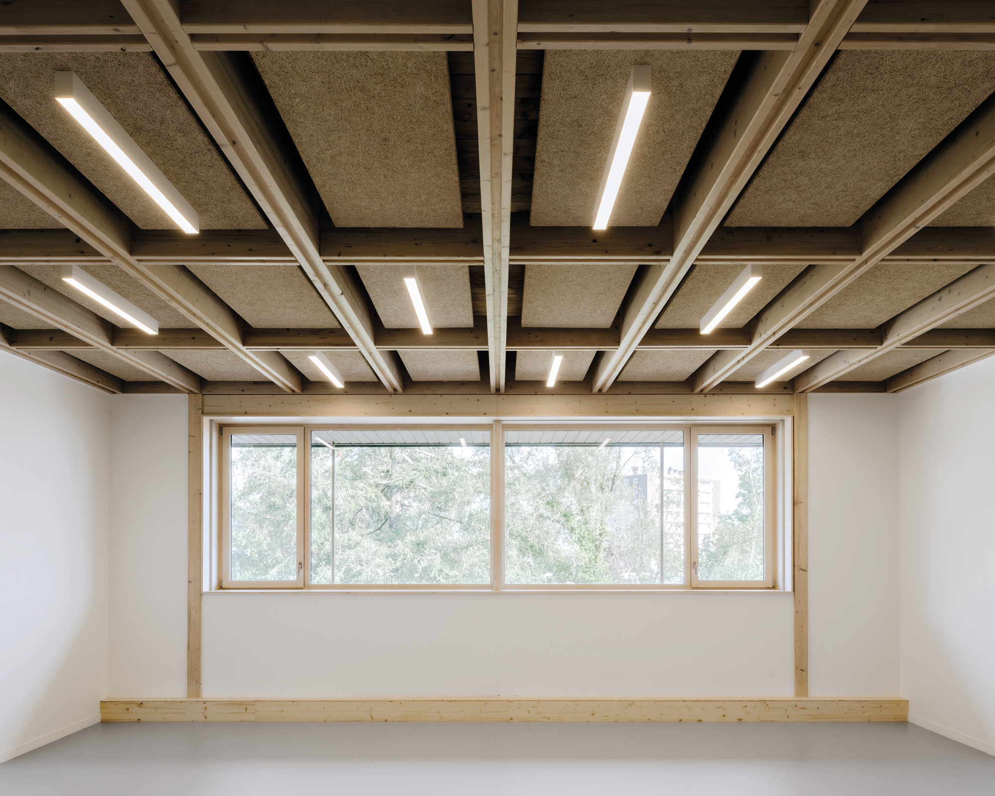 Lediglich der Materialwechsel von Beton zu Holz lässt erahnen, ob man sich im Altbau befindet oder in der eingeschossigen Aufstockung.